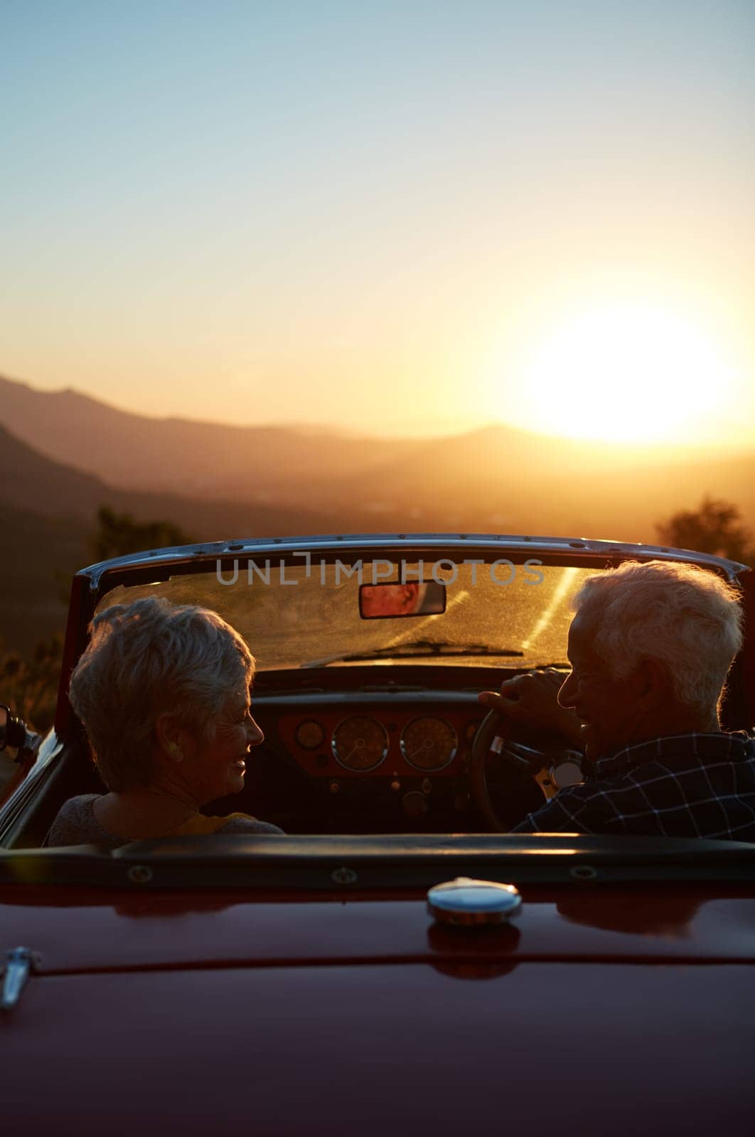Their retirement is one big adventure. a senior couple enjoying the sunset during a roadtrip. by YuriArcurs