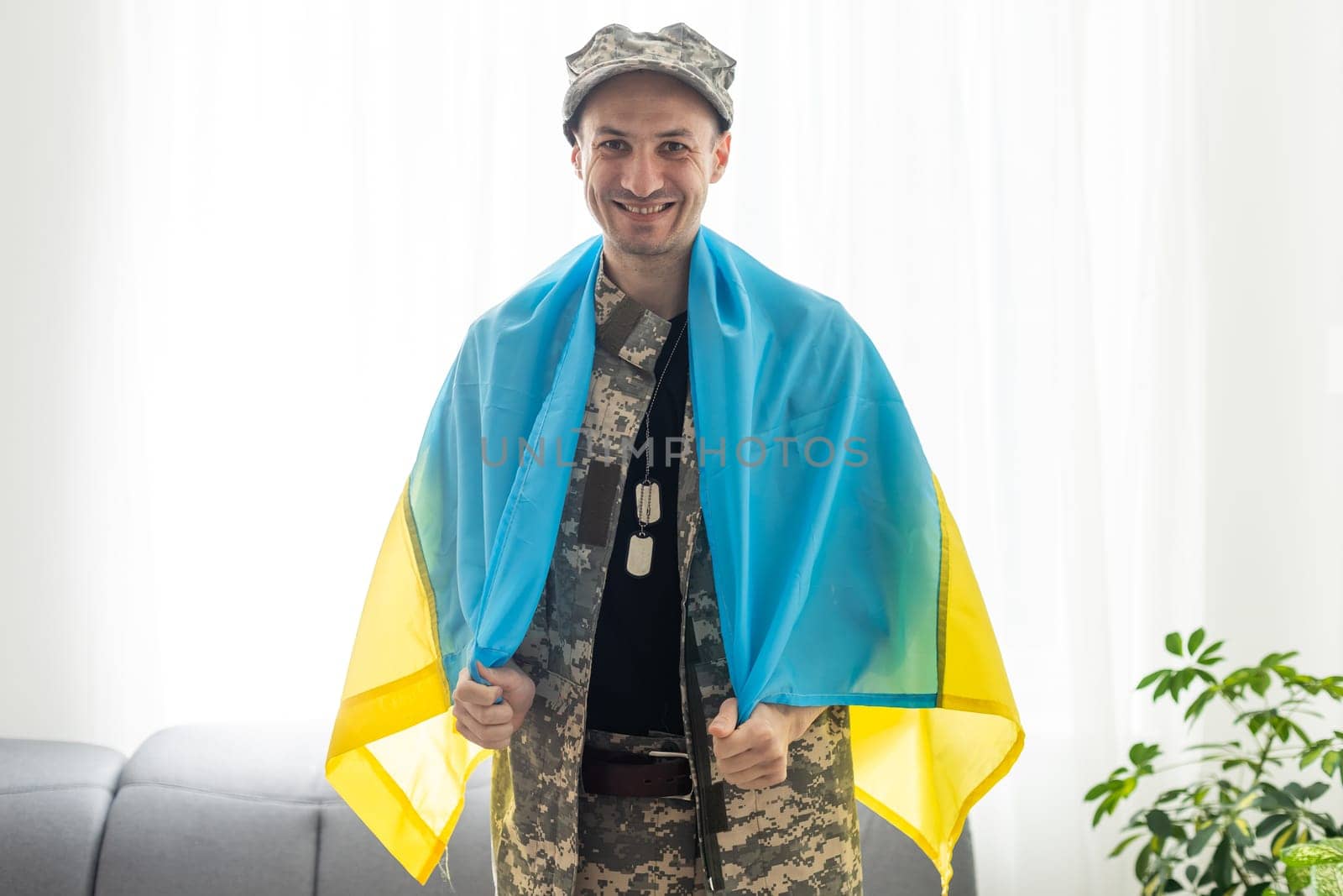 Portrait of a courageous Ukrainian military man holding the flag of Ukraine, freedom concept