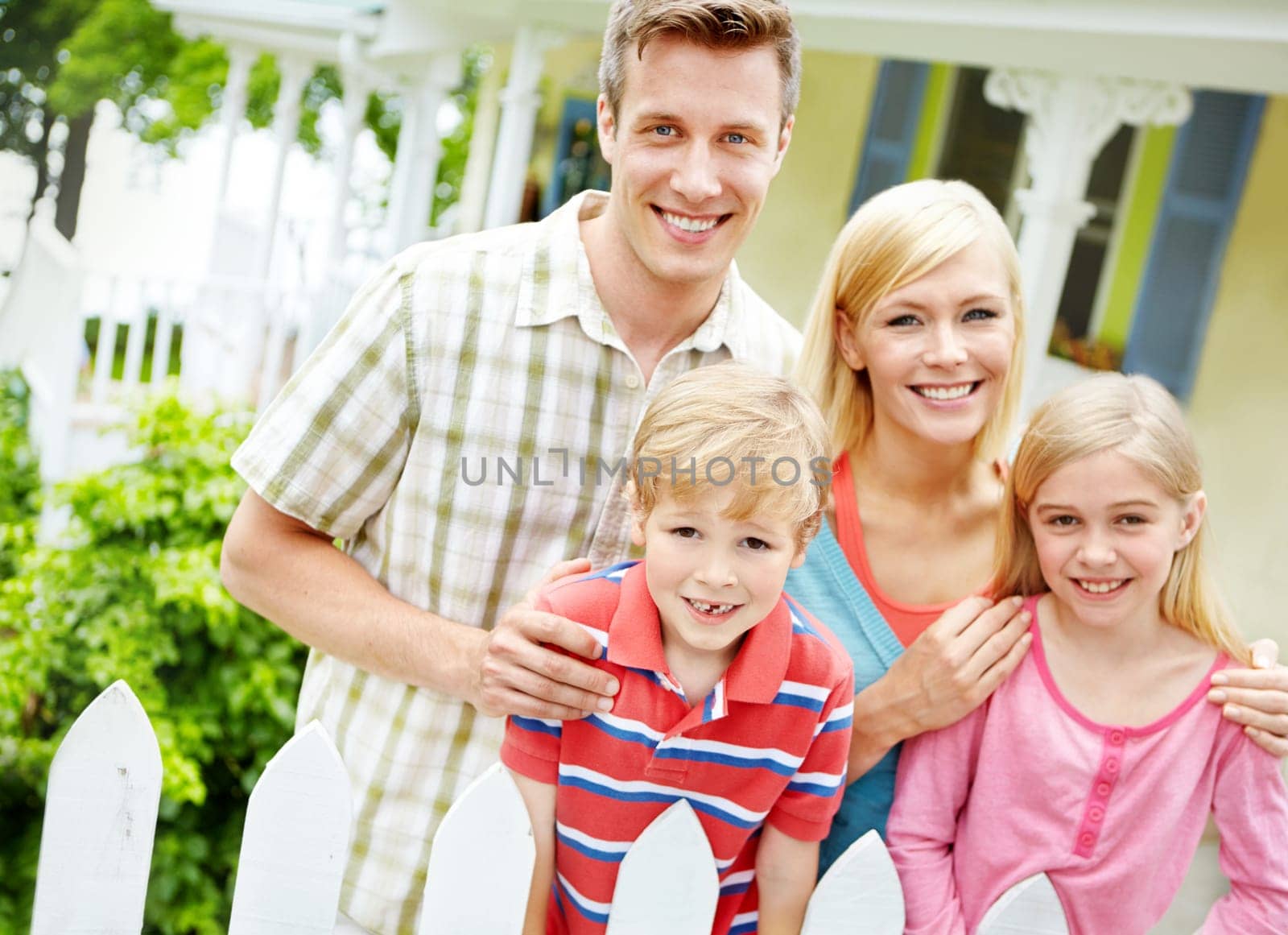 As close as family can be. a young family of four outside