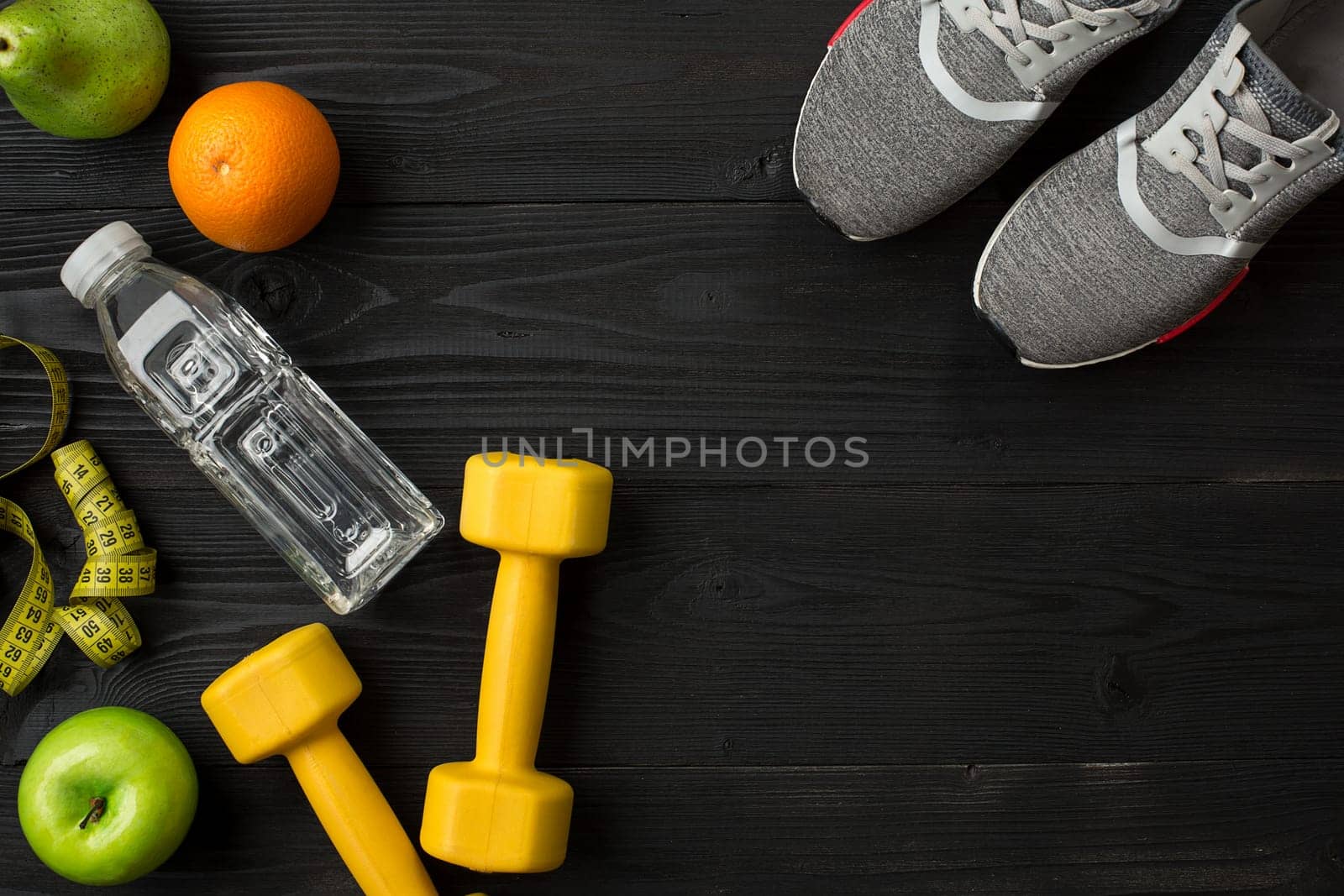Workout plan with fitness food and sport equipment on dark background, top view. Copy space. Still life