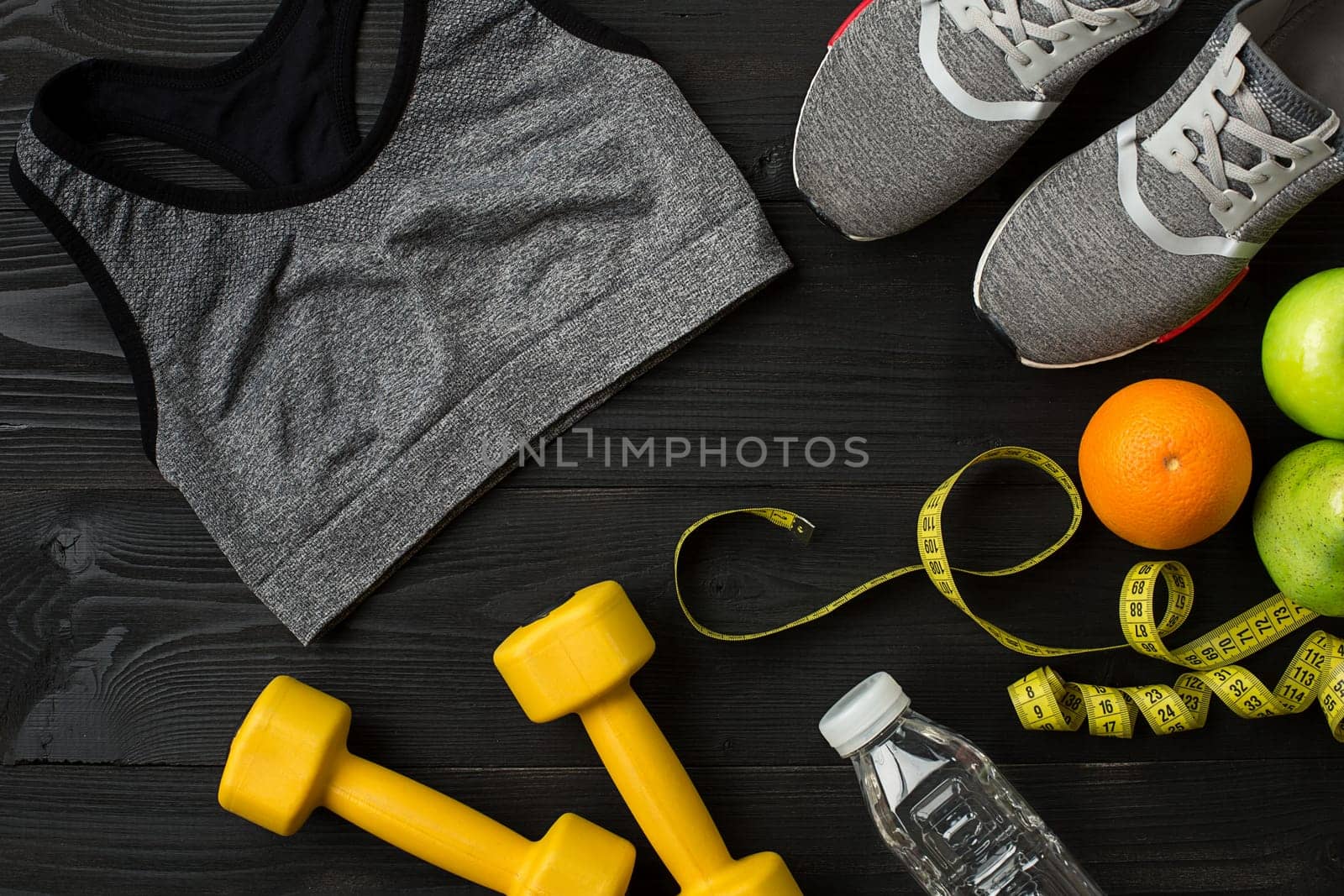 Workout plan with fitness food and sport equipment on dark background, top view. Copy space. Still life