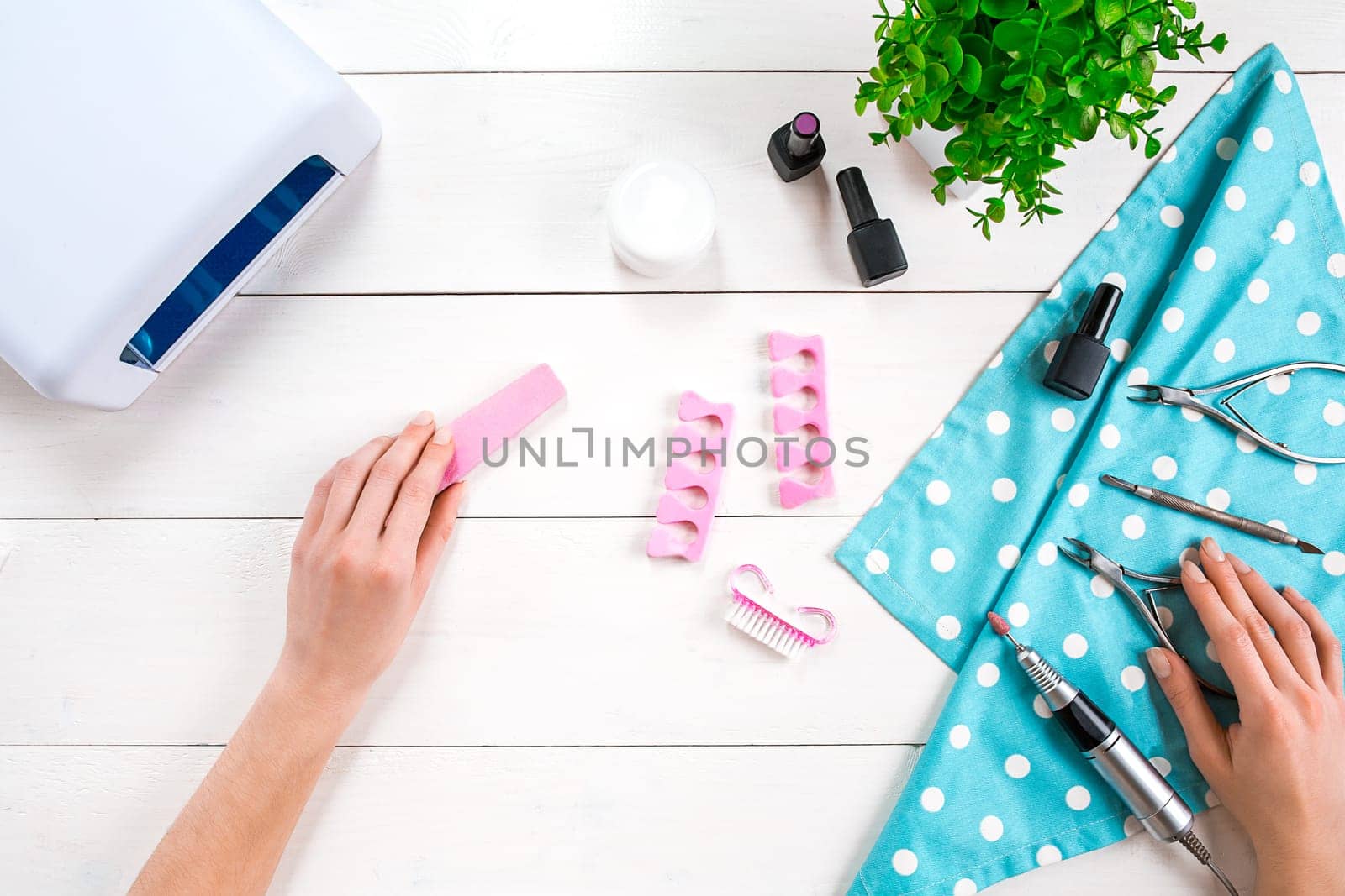 Woman Hands Care. Top View Of Beautiful Smooth Woman's Hands With Professional Nail Care Tools For Manicure On White Background. by nazarovsergey