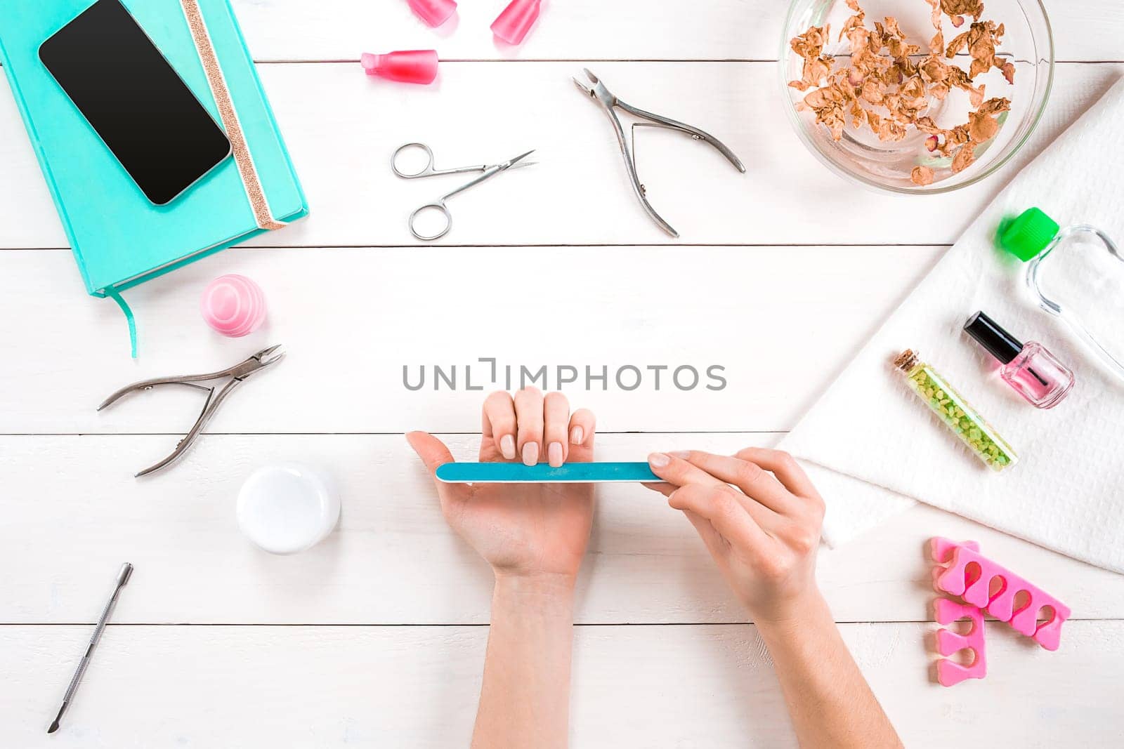 Woman Hands Care. Top View Of Beautiful Smooth Woman's Hands With Professional Nail Care Tools For Manicure On White Background. by nazarovsergey