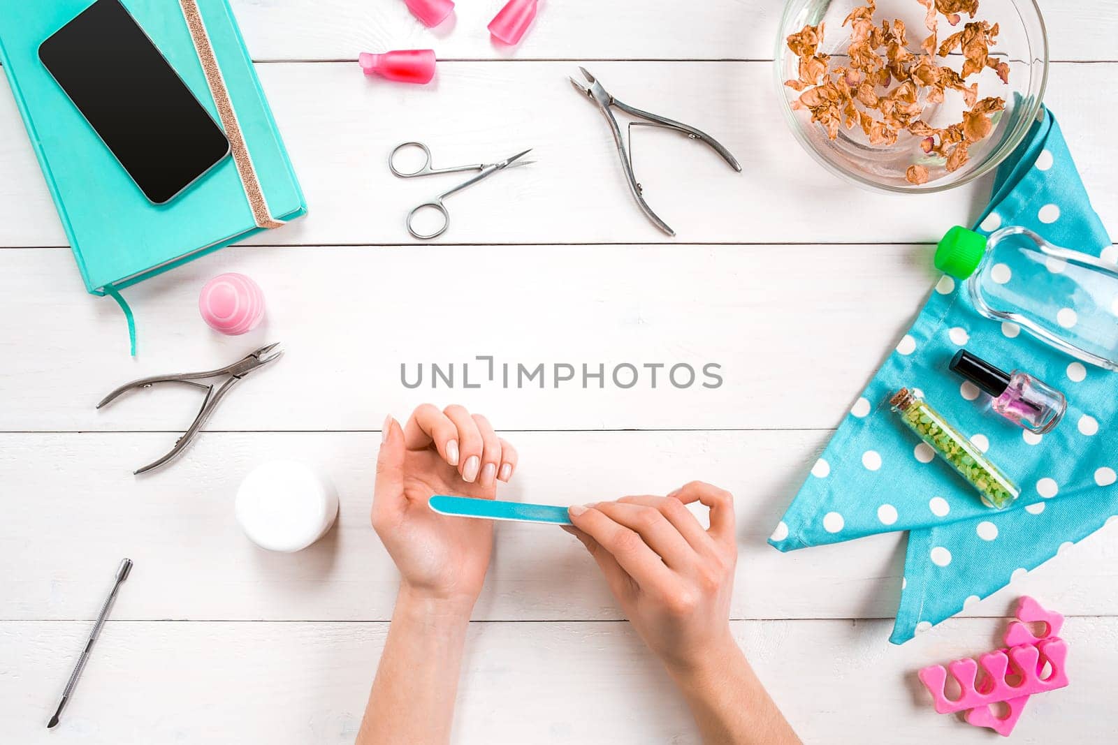 Woman Hands Care. Top View Of Beautiful Smooth Woman's Hands With Professional Nail Care Tools For Manicure On White Background. by nazarovsergey