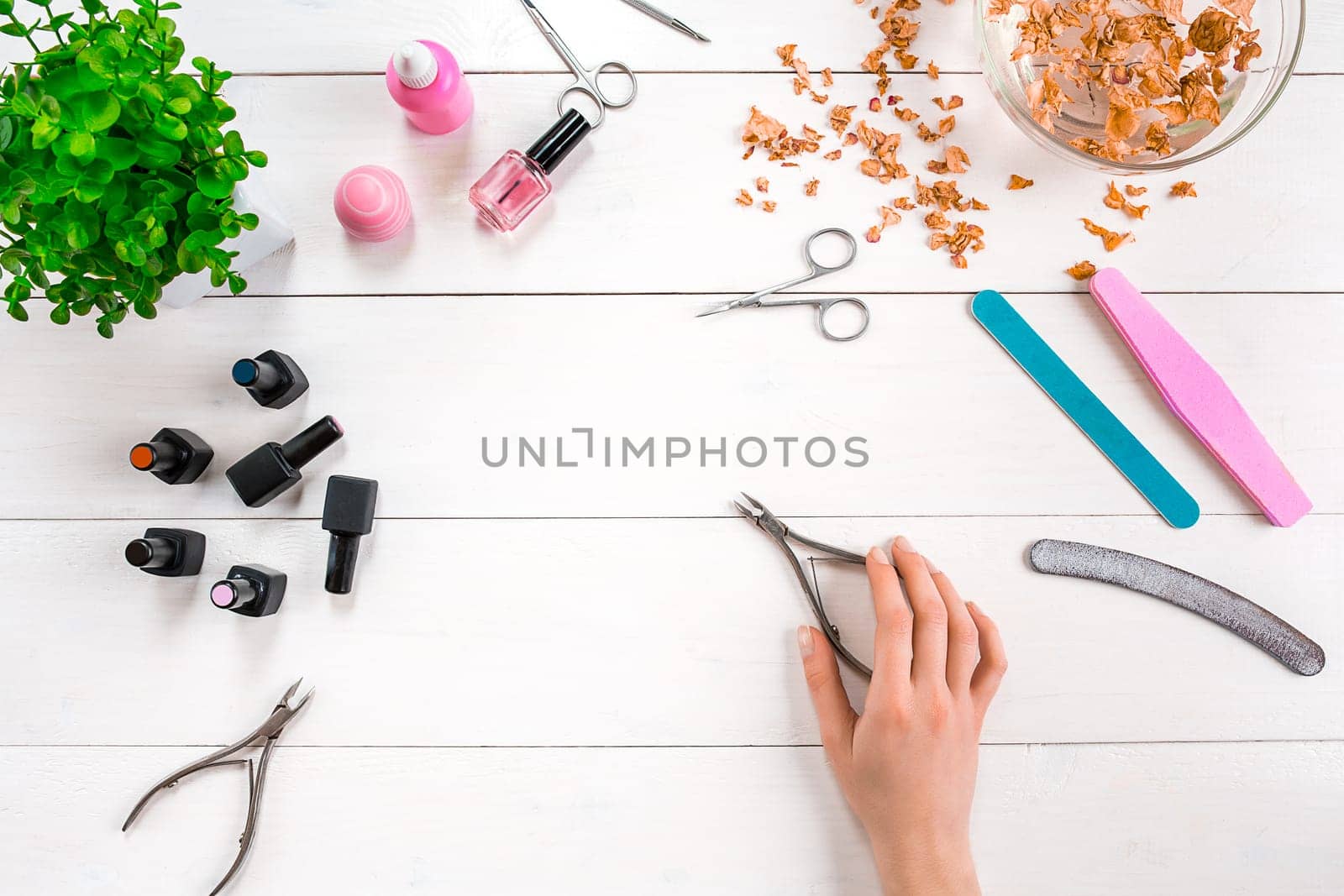 Woman Hands Care. Top View Of Beautiful Smooth Woman's Hands With Professional Nail Care Tools For Manicure On White Background. by nazarovsergey