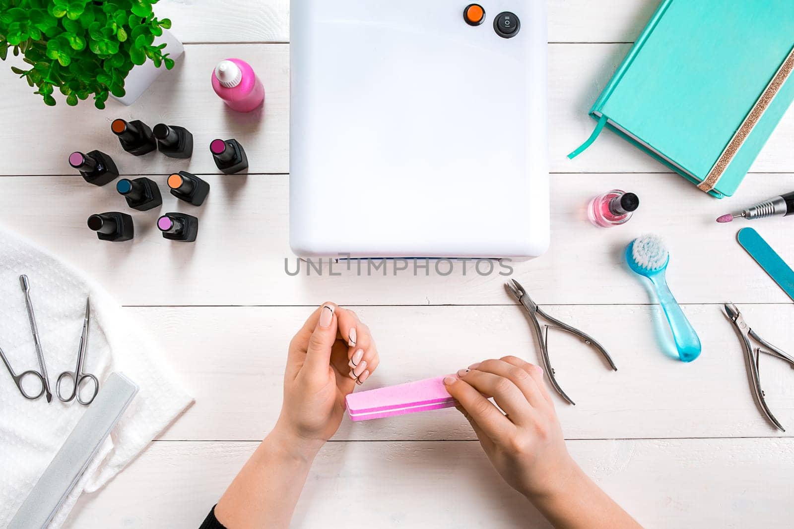 Woman Hands Care. Top View Of Beautiful Smooth Woman's Hands With Professional Nail Care Tools For Manicure On White Background. by nazarovsergey