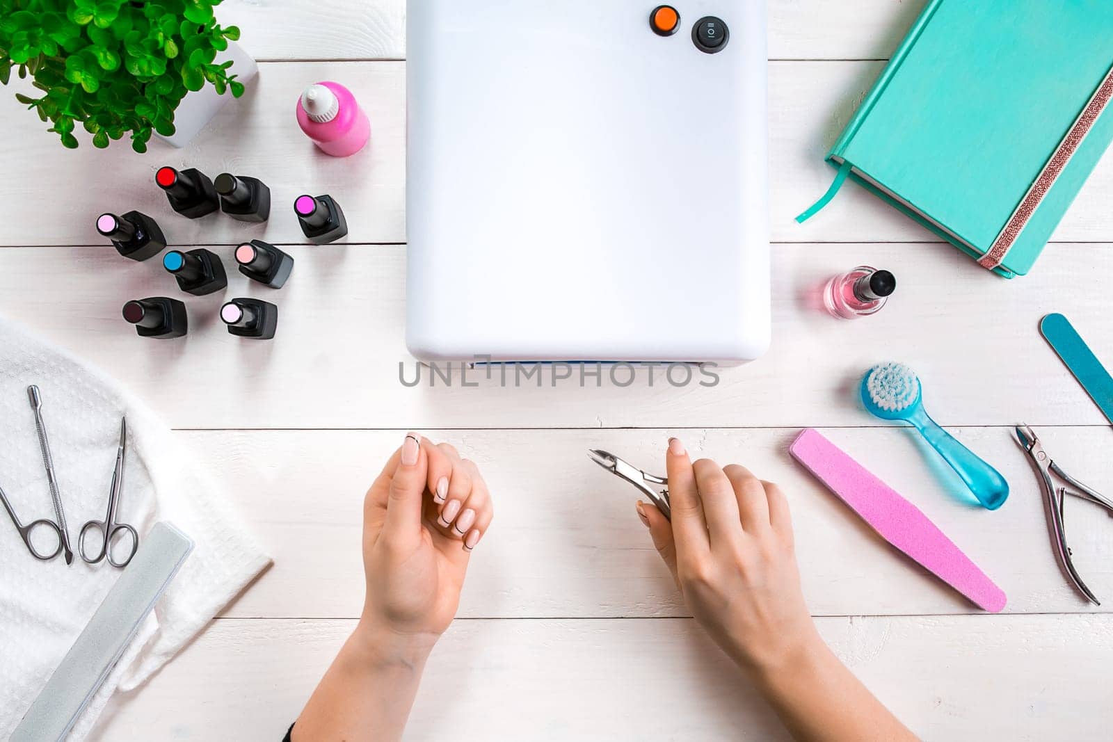 woman hands making manicure to herself on wooden background. Top view. Copy space. Nail Care.