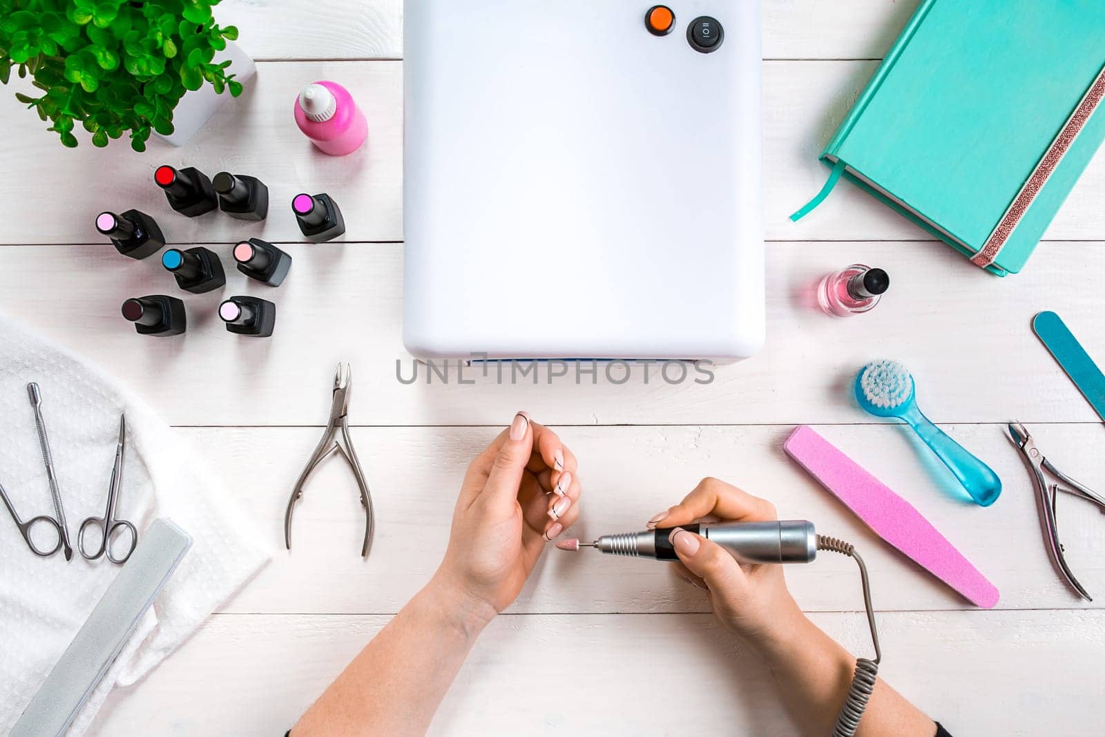 woman hands making manicure to herself on wooden background. Top view. Copy space. Nail Care.