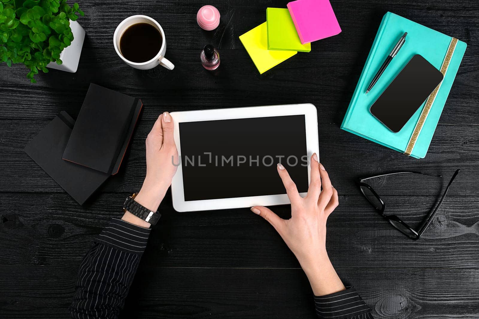 Hand use tablet on desk table top view. Copy space. Flat lay. Black background