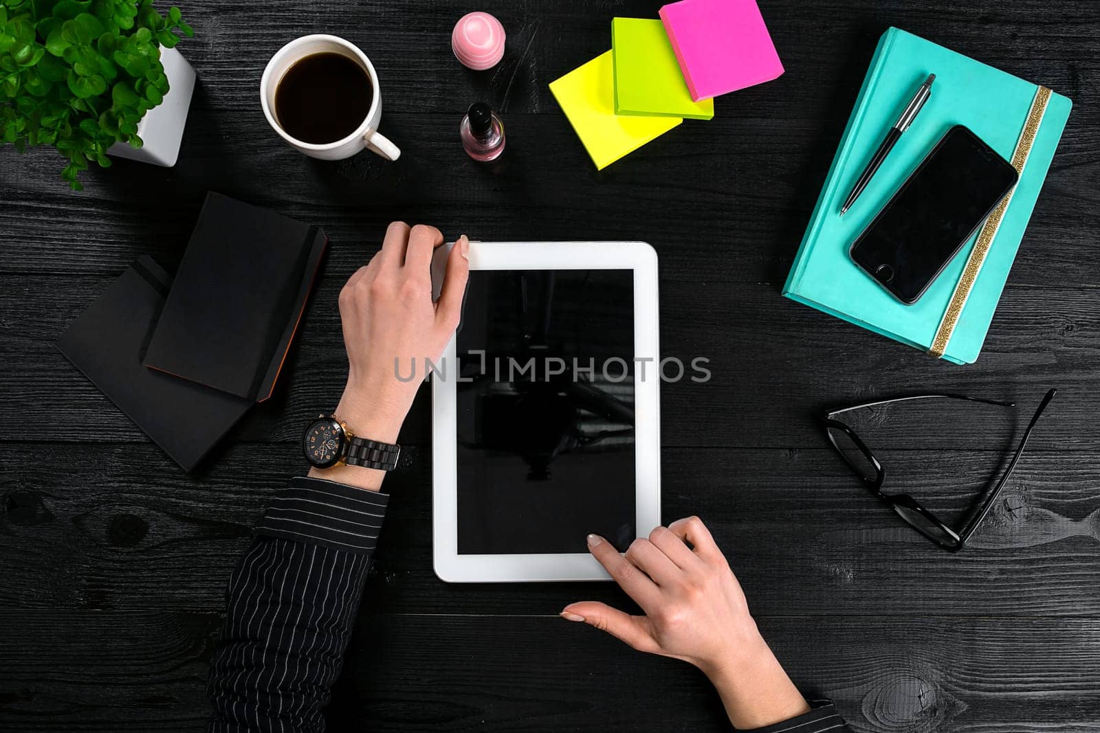 Hand use tablet on desk table top view. Copy space. flat lay on black background
