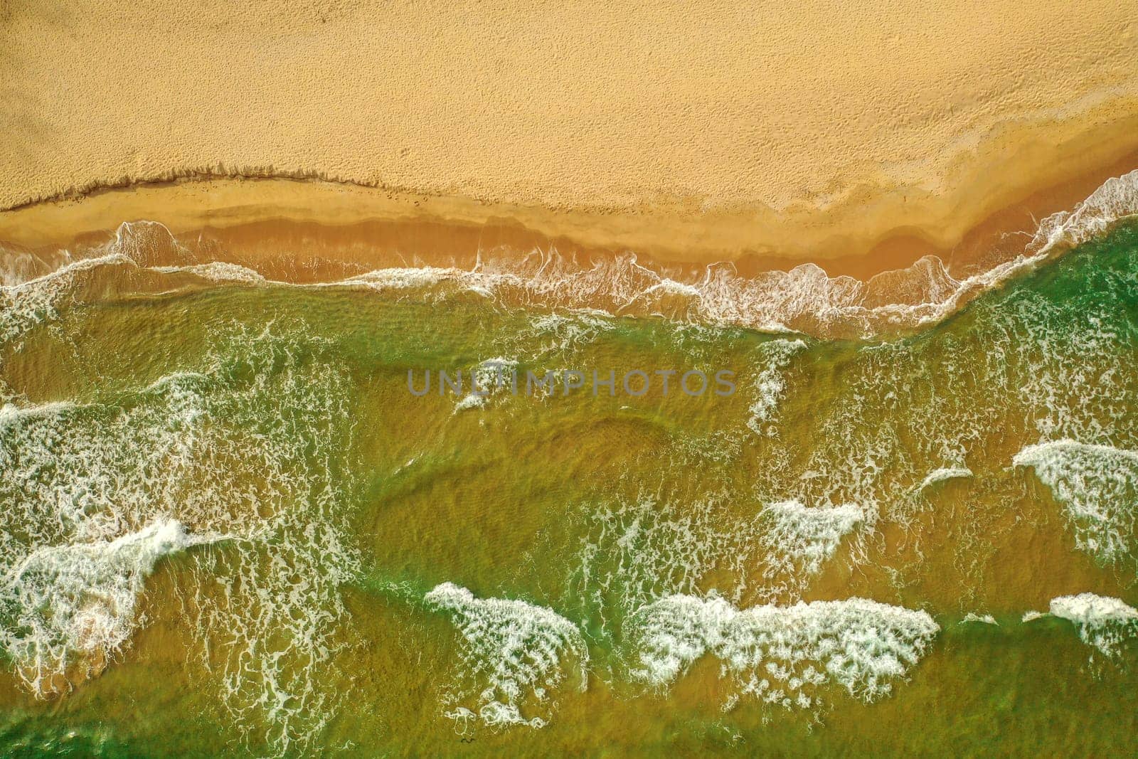 Summer is coming concept. Sandy beach, panorama. Top view Aerial of the sandy beach. The sea wave rolls on the shore. Sea coast view from the air