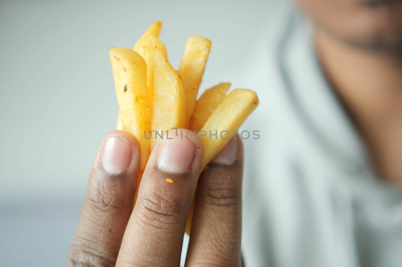 men eating french fries close up.
