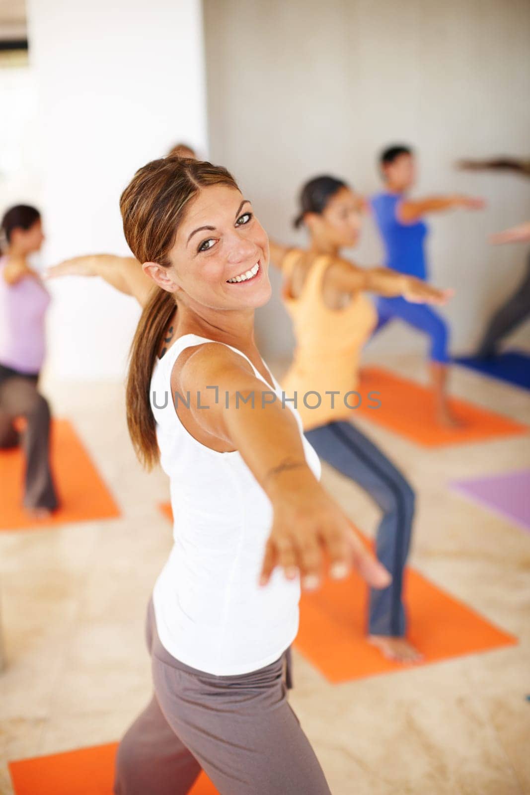 A gorgeous young woman in a yoga class in a yoga position.