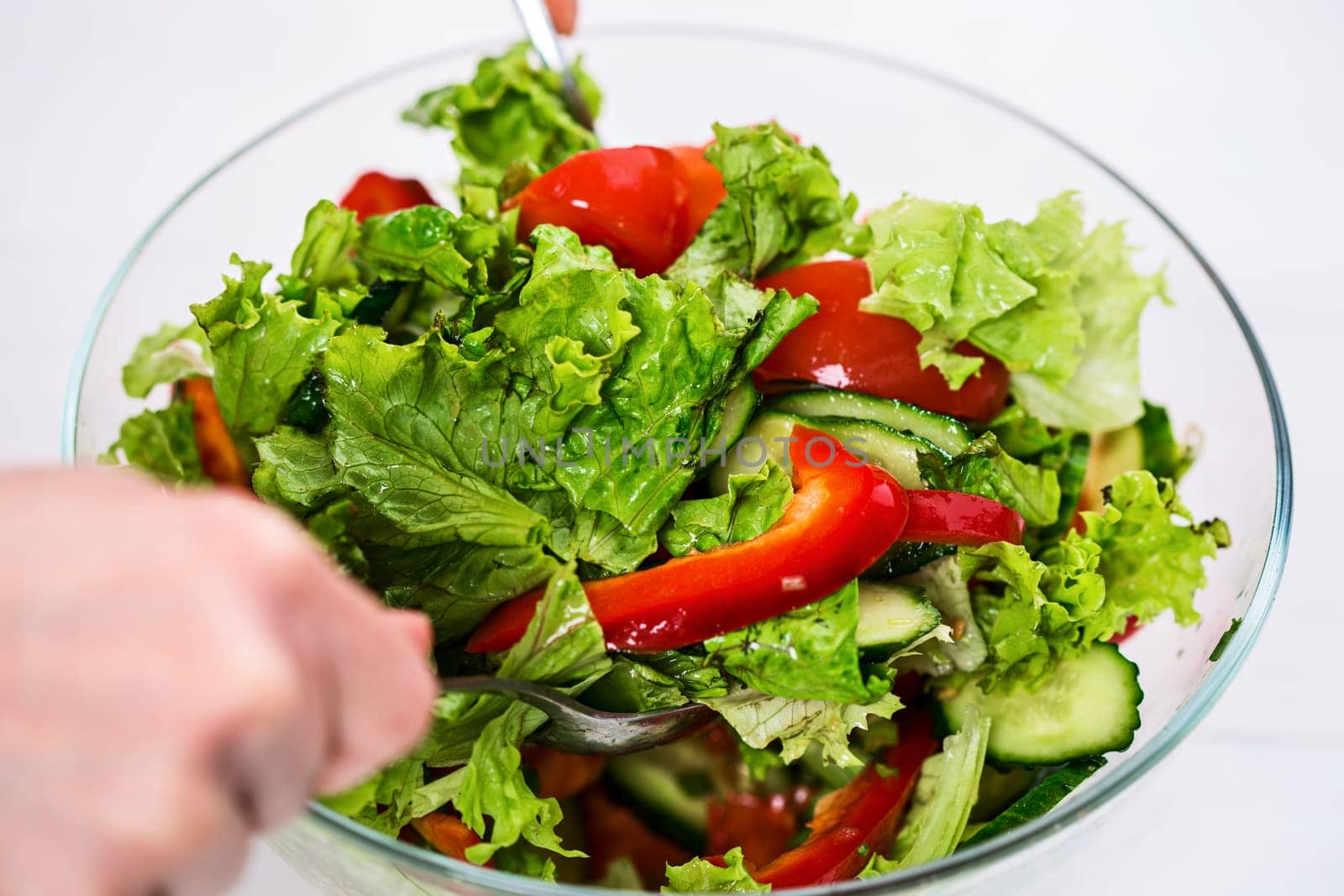 Healthy eating, vegetarian food, dieting and people concept - close up of young woman dressing vegetable salad with olive oil on a white background