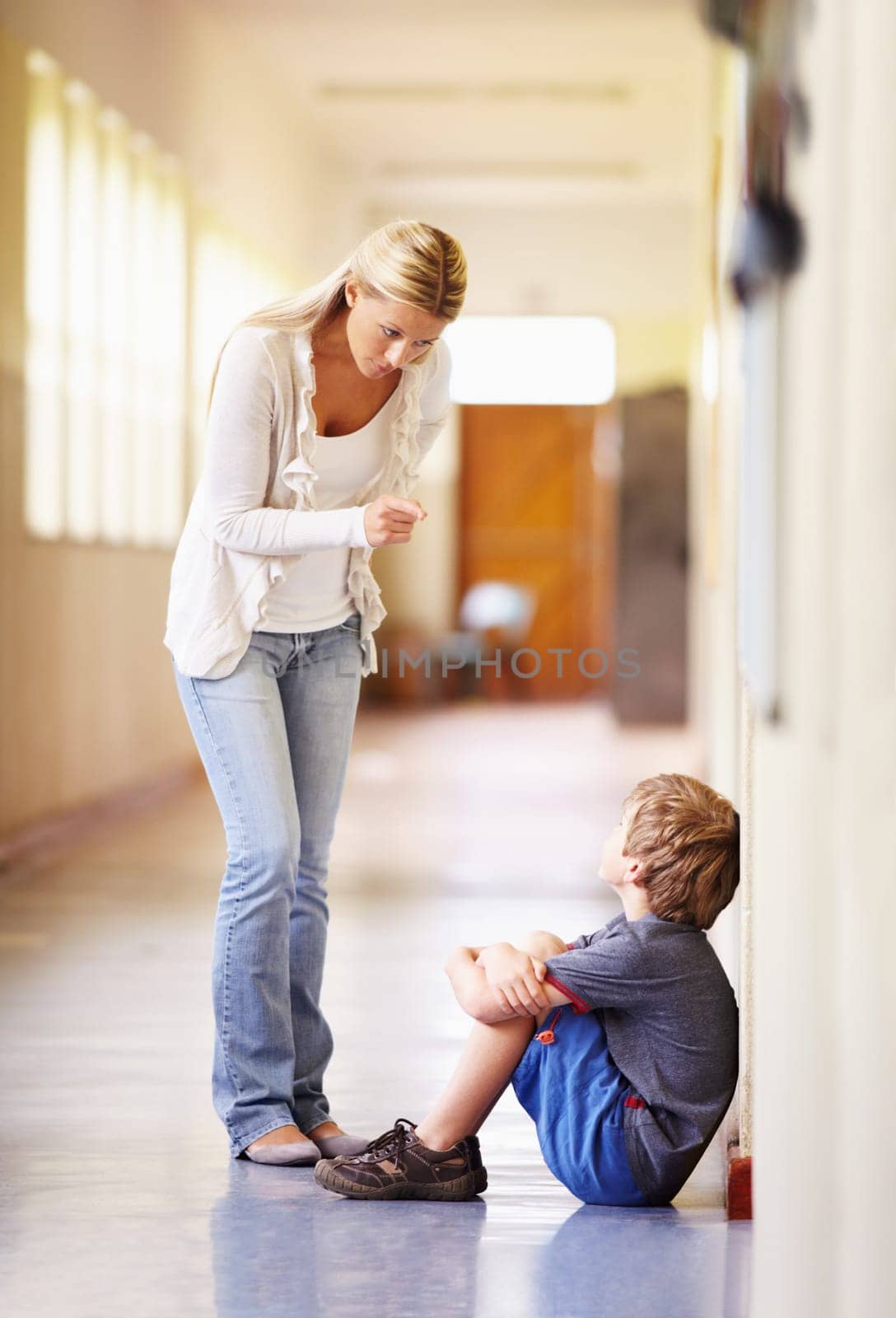 Teacher, school and scolding child student for bad behaviour, problem or learning lesson. Frustrated woman pointing to punish boy for discipline, pedagogy or fail in education building hallway by YuriArcurs