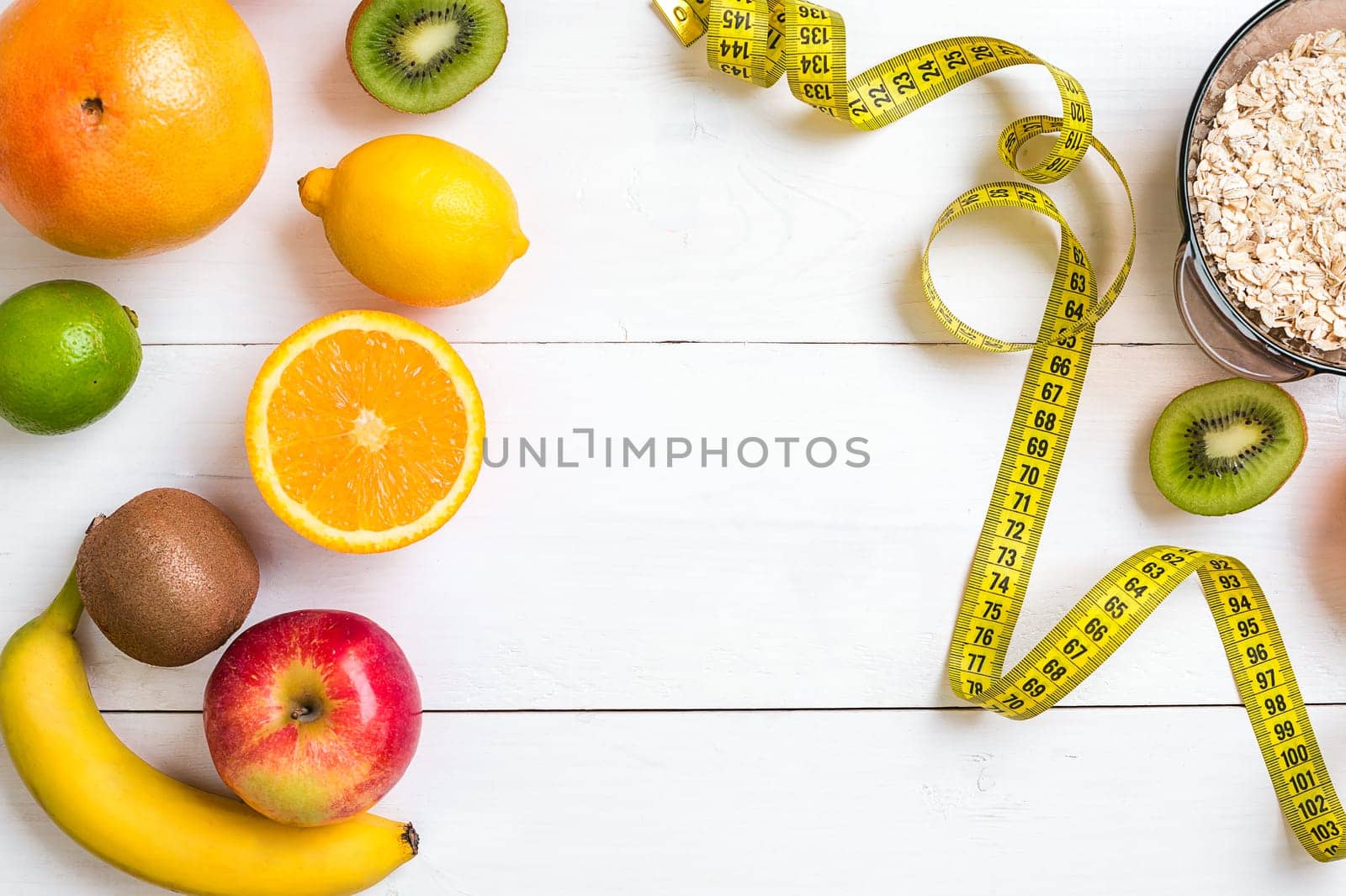 Fitness concept with fruit, bowl of oatmeal and centimeter. Top view background concept. by nazarovsergey