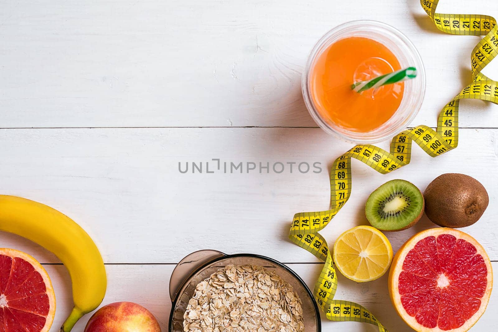 Fitness concept with fruit, bowl of oatmeal and centimeter. Top view background concept. Copy space