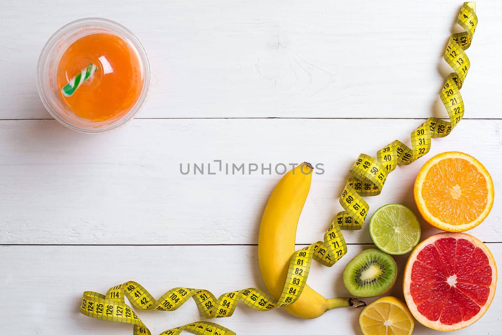 Fitness concept with fruit, bowl of oatmeal and centimeter. Top view background concept. Copy space