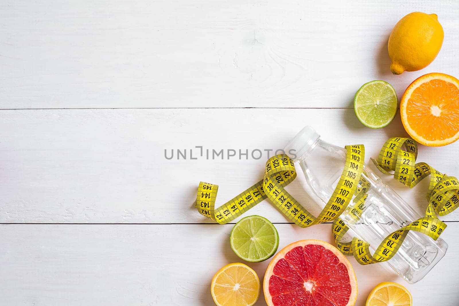 Fresh fruits with tape measure over white wooden background. Fitness concept. Top view. Copy space Flat lay Flat lay