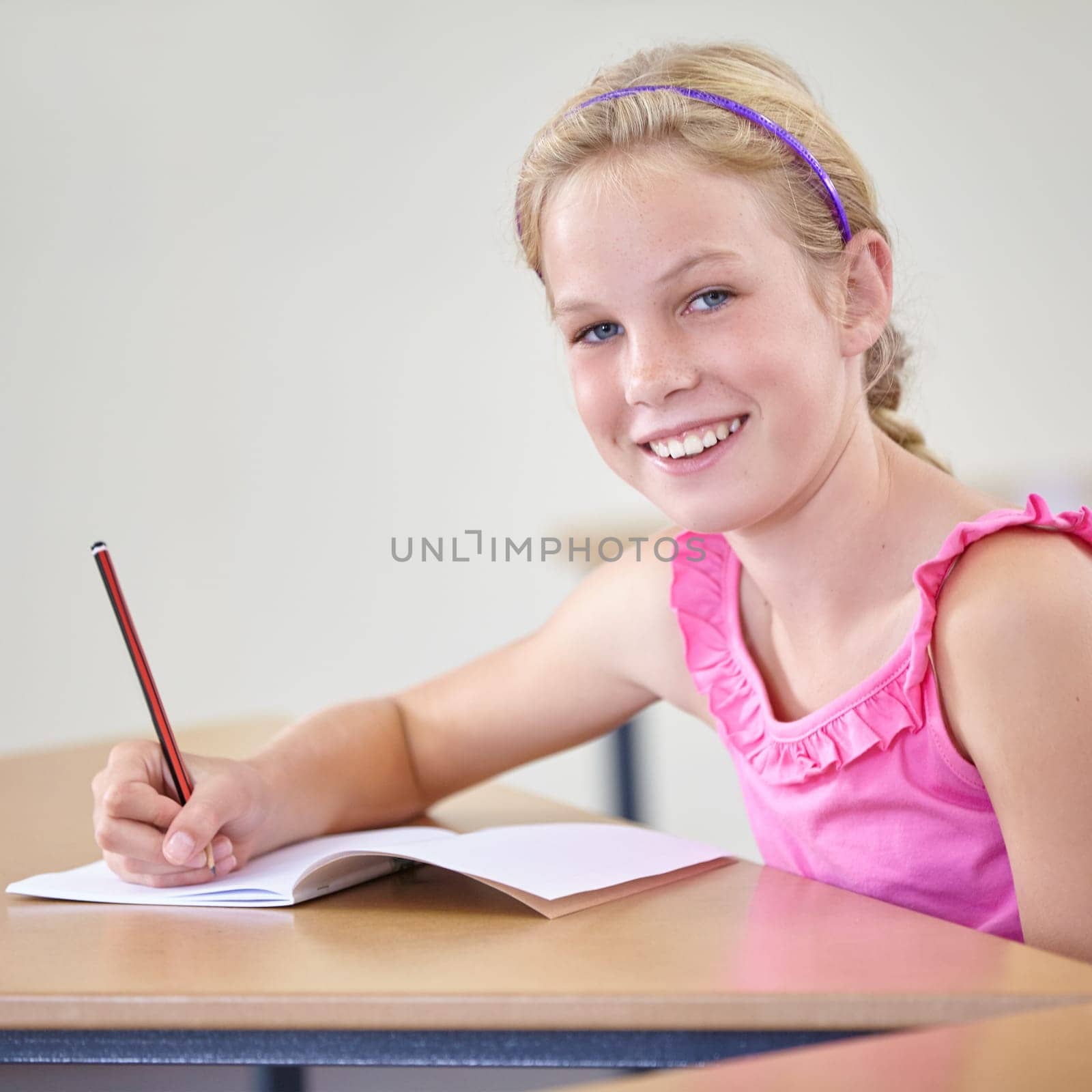 Portrait, child and education of student taking notes in classroom for knowledge, development and happy. Smile, girl and learner writing in notebook, studying or learning in middle school in Canada