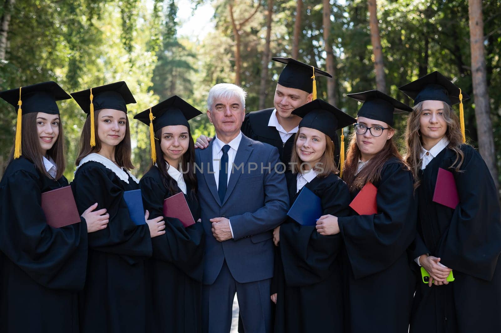 University professor and seven graduates rejoice at graduation. by mrwed54