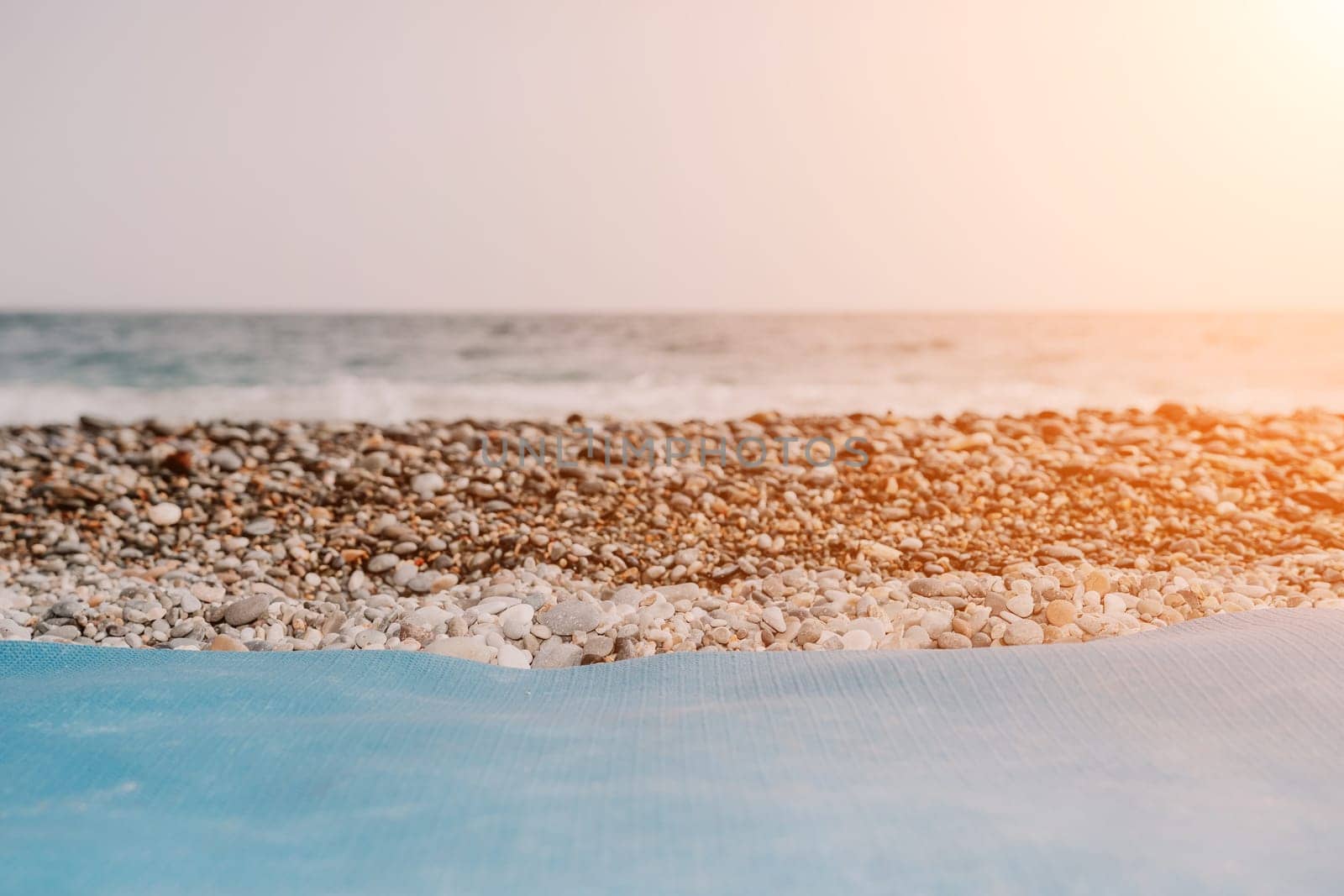 Blue yoga mat is on a sandy beach by the sea