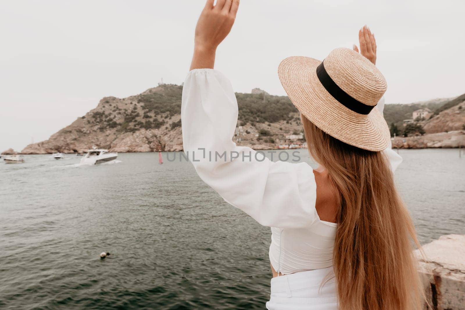 Woman summer travel sea. Happy tourist in hat enjoy taking picture outdoors for memories. Woman traveler posing on the beach at sea sharing travel adventure journey by panophotograph