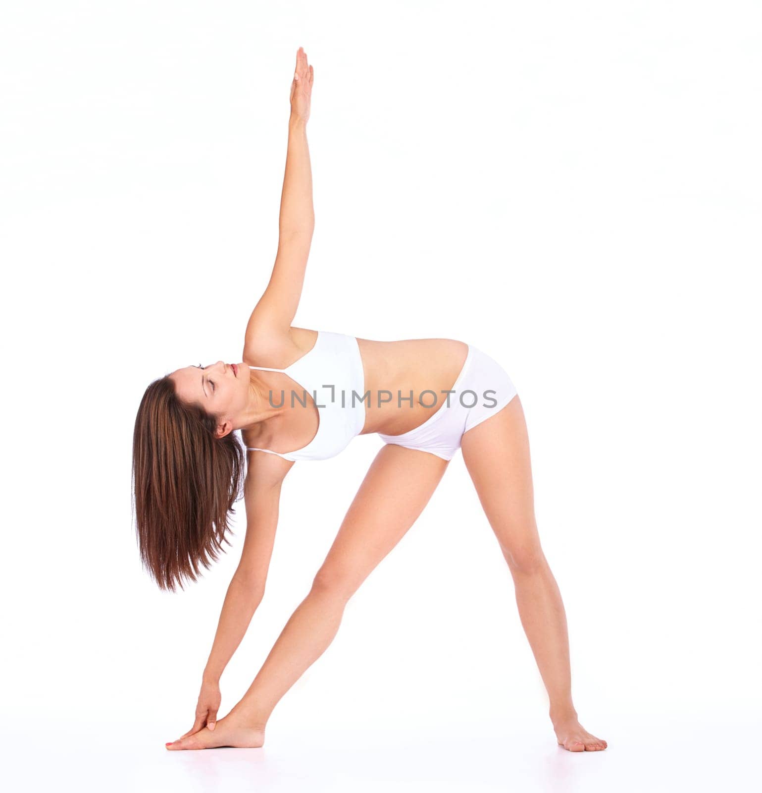 Woman, healthy body and yoga with stretching in studio for wellness, health and fitness by white background. Young isolated model, girl and lingerie with training, workout and focus in underwear by YuriArcurs