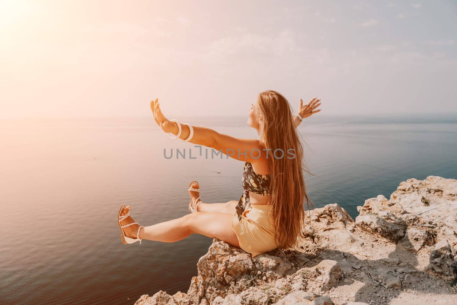 Woman travel sea. Happy tourist taking picture outdoors for memories. Woman traveler looks at the edge of the cliff on the sea bay of mountains, sharing travel adventure journey.