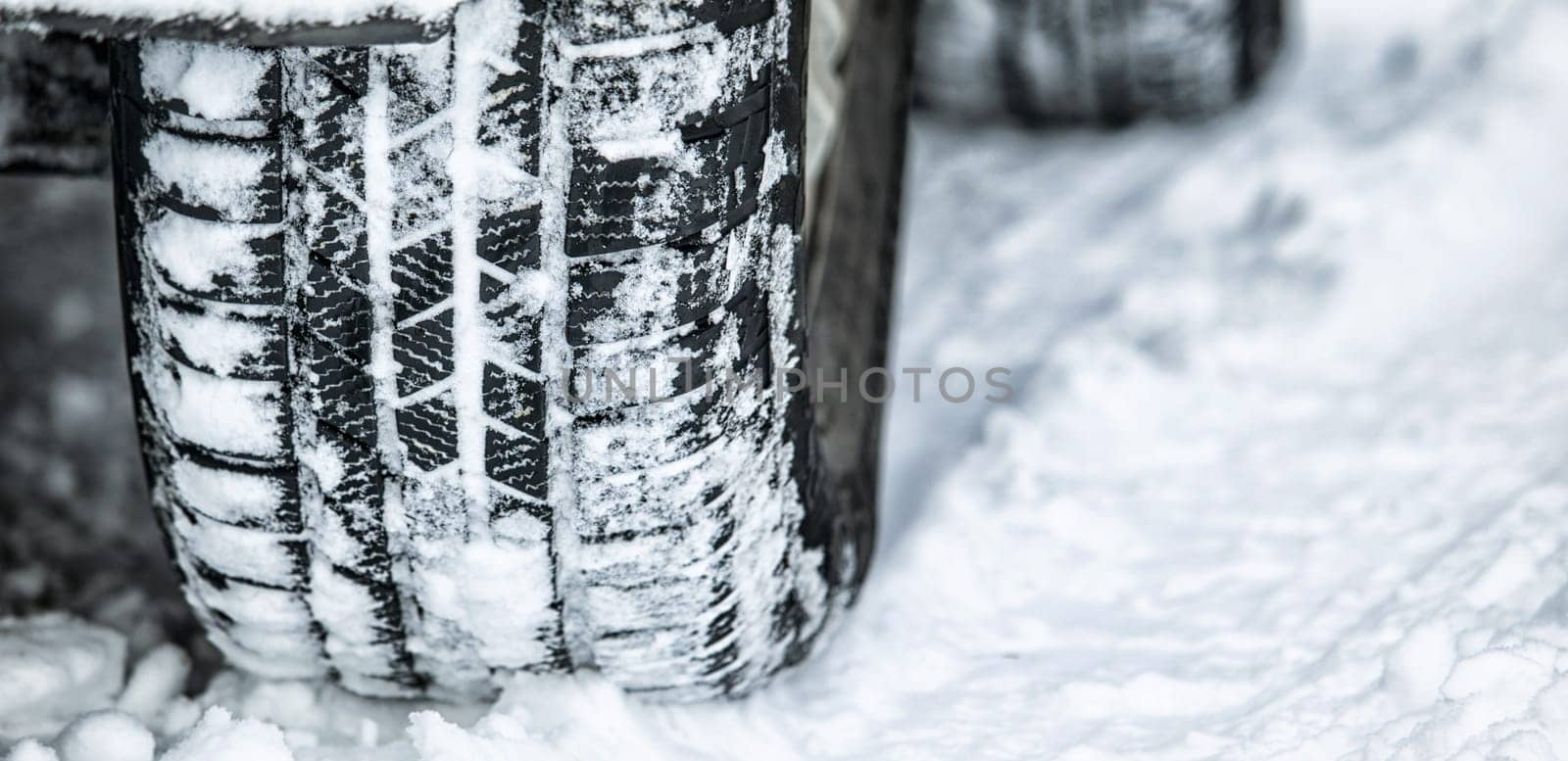 Tire, winter and car driving in snow or ice for a road trip, travel and outdoor journey using transport in cold weather. Ice, transportation and vehicle drive or traveling on a track in nature by YuriArcurs