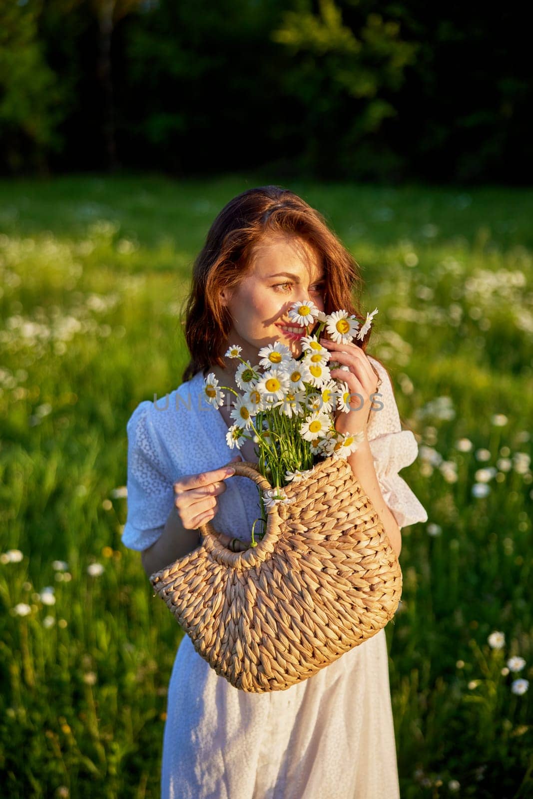 portrait of a beautiful, happy red-haired woman holding a basket of daisies in her hands by Vichizh