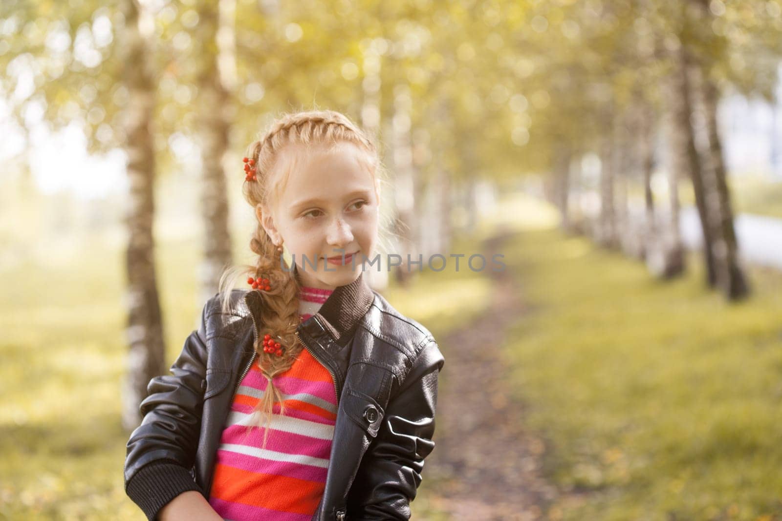 Charming little girl posing in autumn garden, close-up