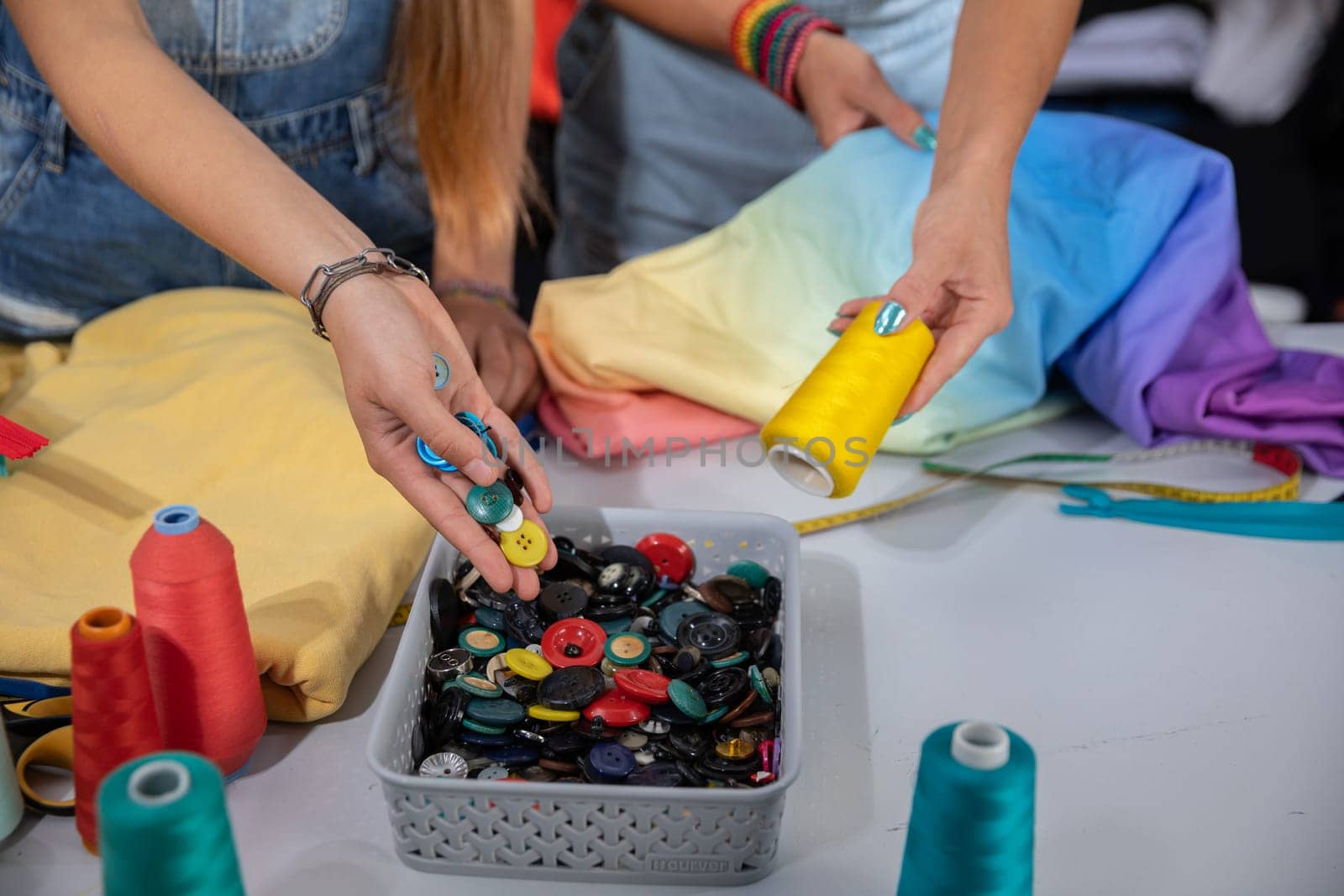 Collaborative color matching for buttons and thread. At work in the back of the sewing studio during the creation of a new collection of garments.