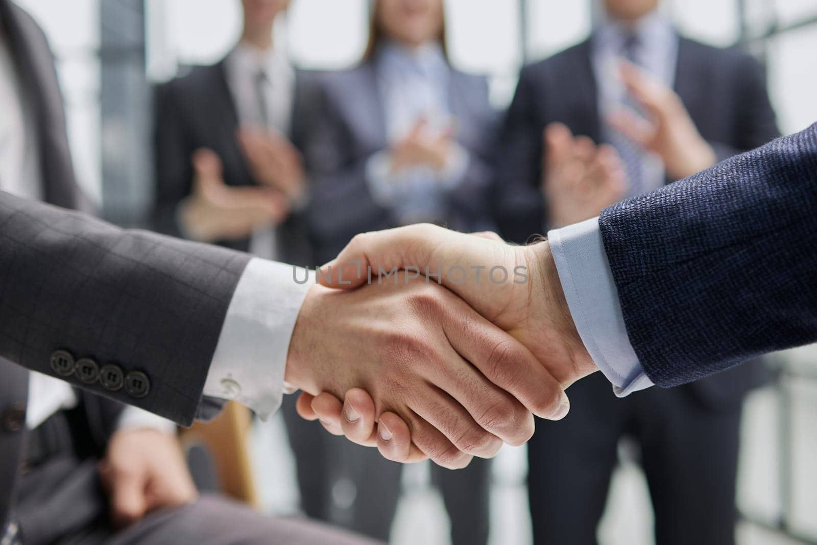 Handshake of two businessmen in the lobby of the modern business center
