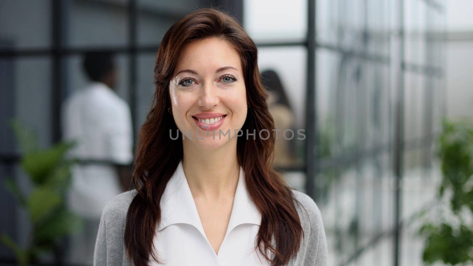 Happy young woman looking at the camera while greeting a client. by Prosto