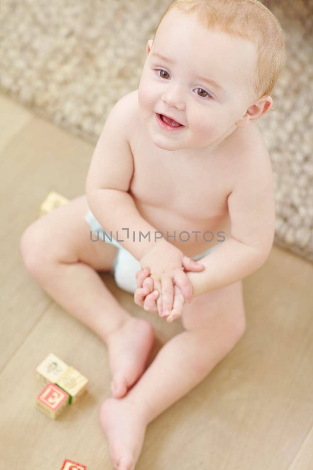 If you sexy and you know it, clap your hands. A cute little boy clapping his hands with his blocks lying next to him