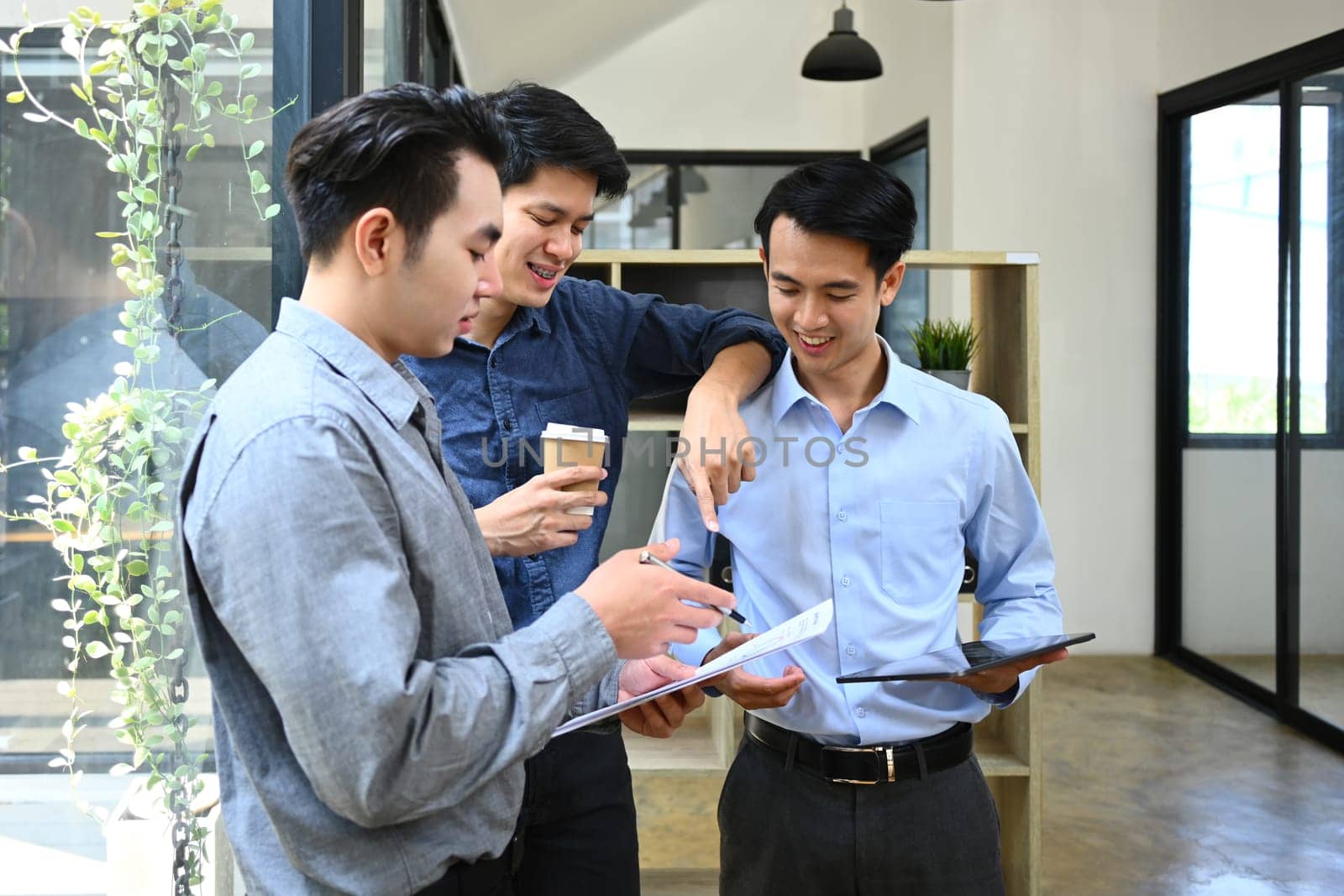 Group of businesspeople discussing startup project sharing business ideas chatting during coffee break in office.