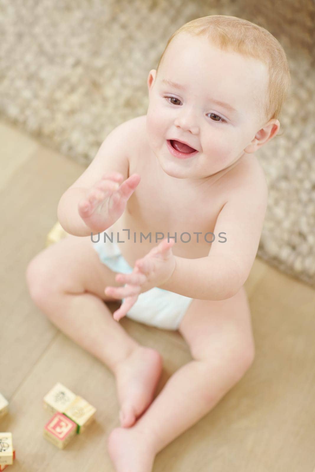 Lets do the clapping song now. A cute little boy clapping his hands with his blocks lying next to him