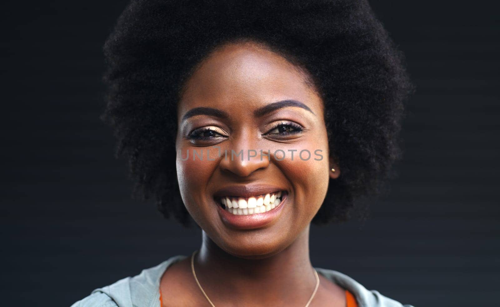 Your smile can change the world. a happy young woman posing against a dark background