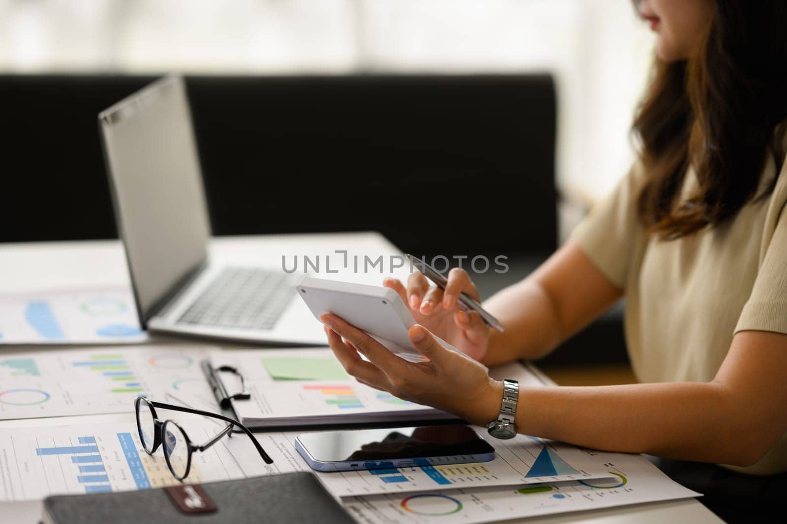 Cropped shot of female accountant working bookkeeping documents, checking financial data at office.