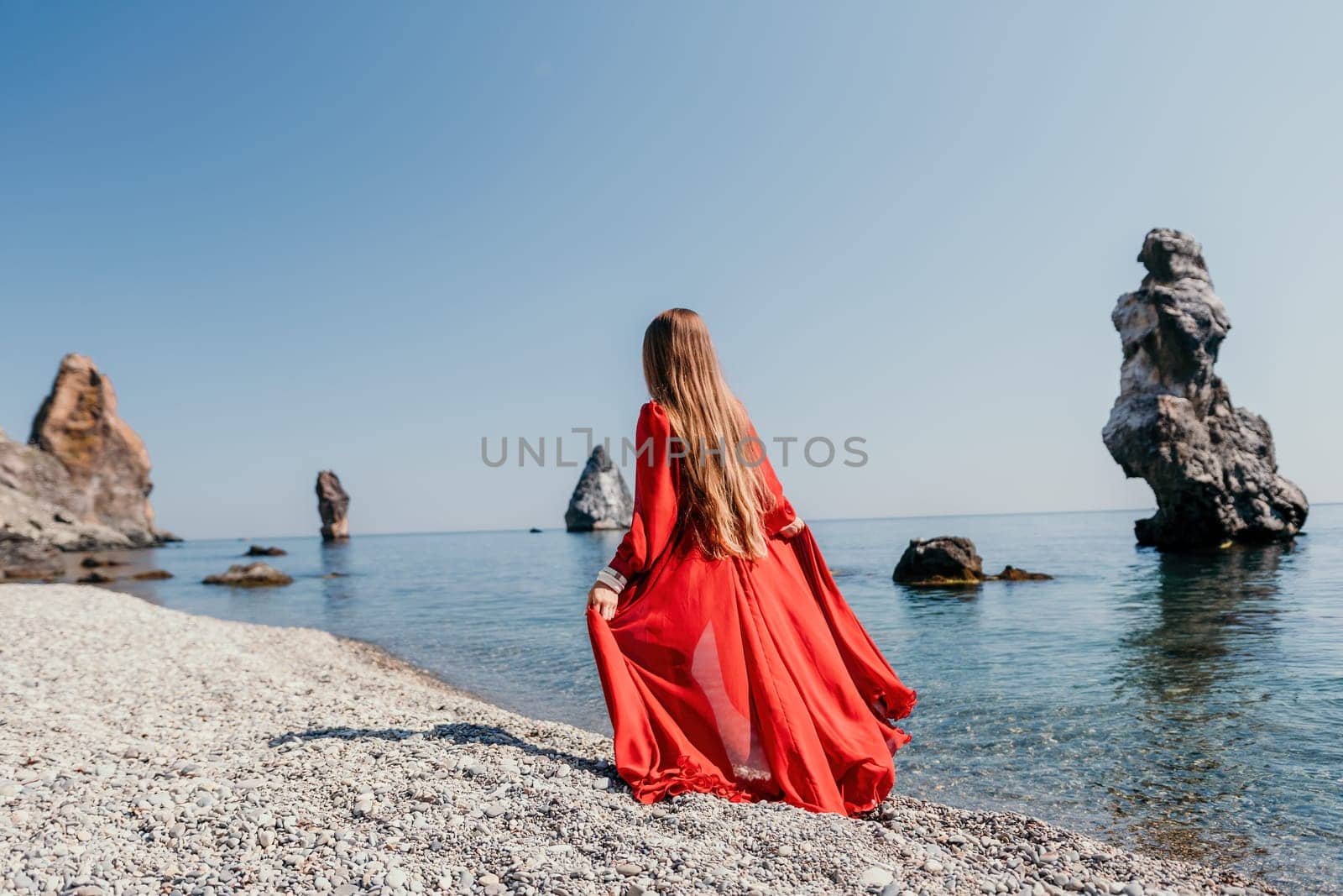 Woman travel sea. Happy tourist taking picture outdoors for memories. Woman traveler looks at the edge of the cliff on the sea bay of mountains, sharing travel adventure journey.