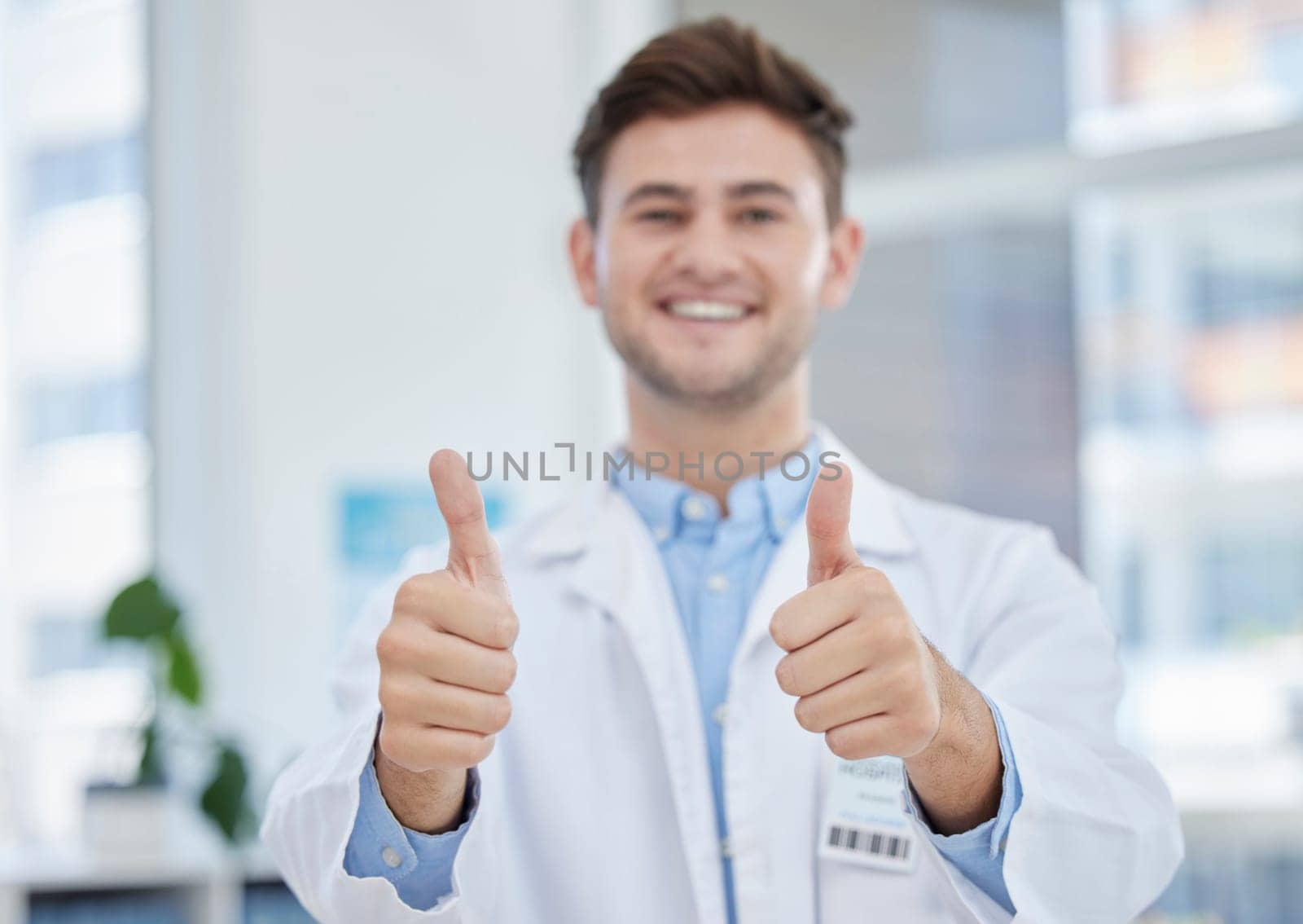 Medical, thumbs up and portrait of happy doctor with hand gesture or sign excited for good news in a clinic. Young, medicine and man healthcare professional in agreement, thank you and satisfied.