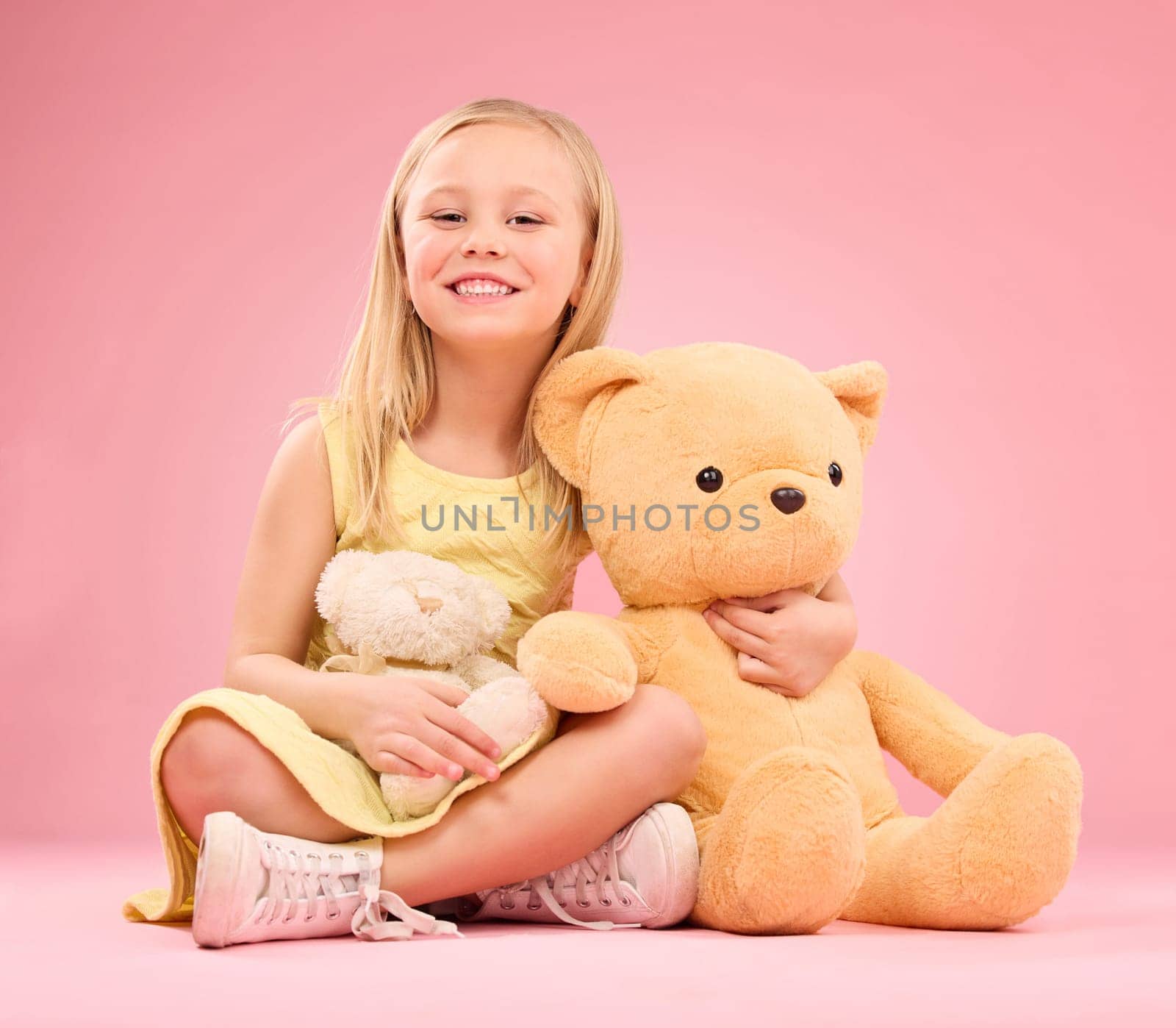 Teddy bears, girl and portrait with soft toys with happiness and love for playing in a studio. Isolated, pink background and a young female child feeling happy, joy and cheerful with stuffed friend by YuriArcurs