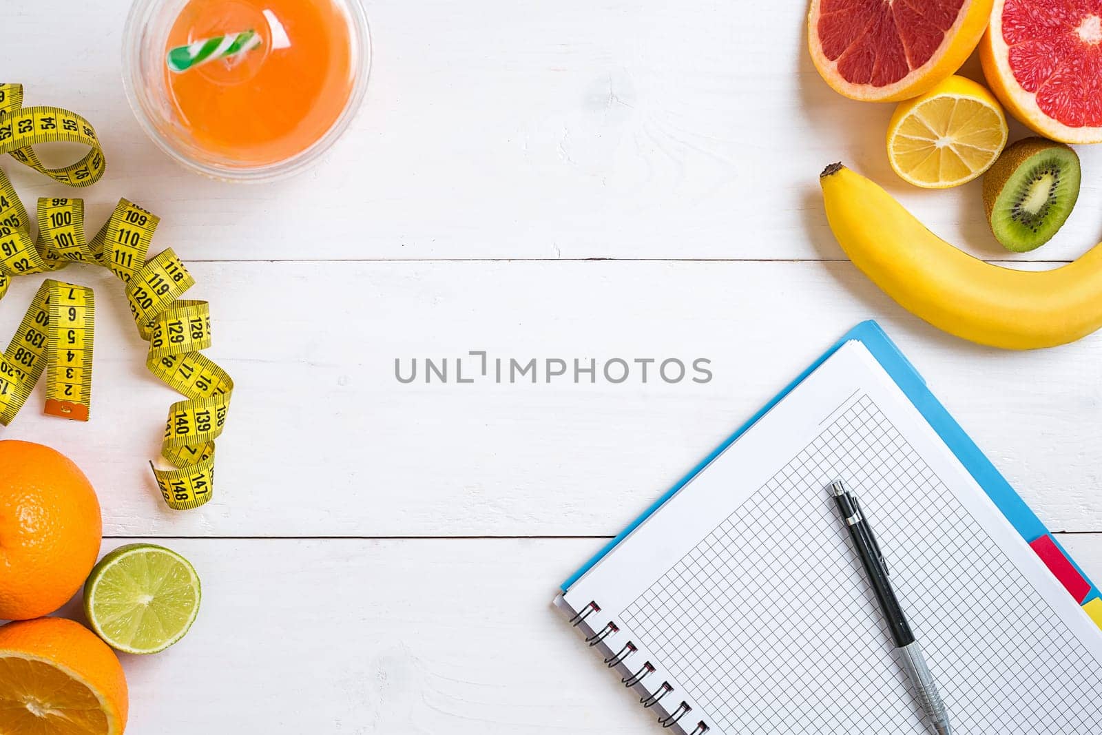 Fitness concept with fruit, bowl of oatmeal and centimeter. Top view background concept. Copy space. Pen and notepad for notes