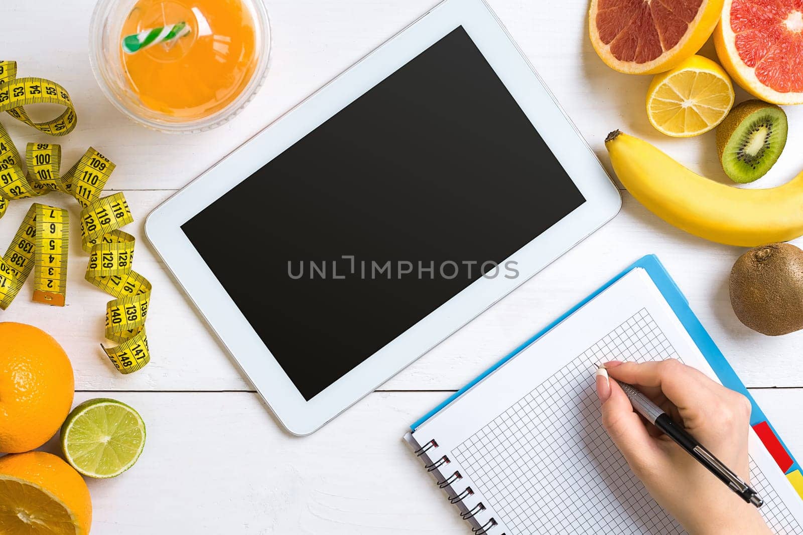 Fresh fruits with tape measure over white wooden background. Fitness concept. Top view. Copy space Flat lay