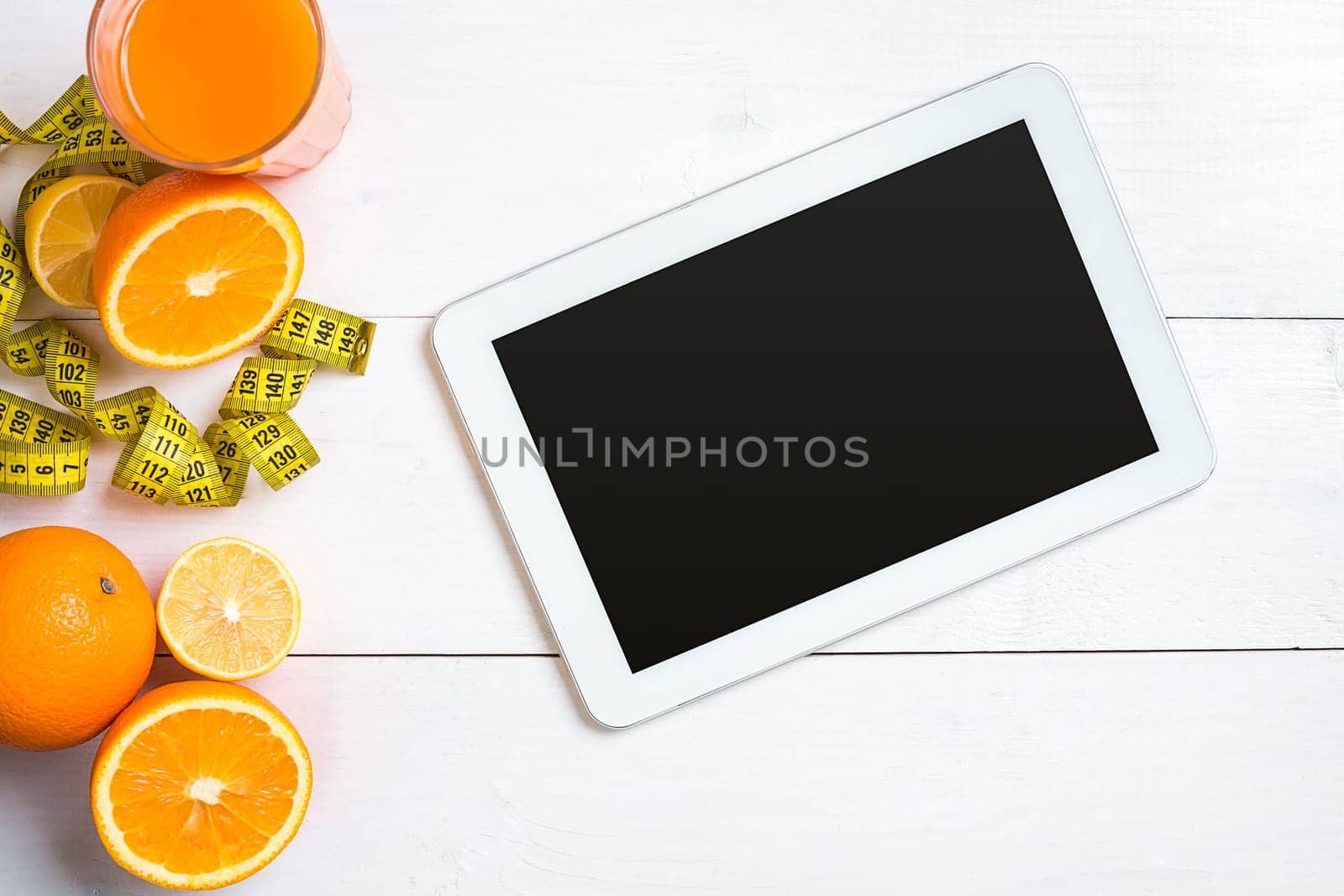 Fresh fruits with tape measure over white wooden background. Fitness concept. Top view. Copy space Flat lay
