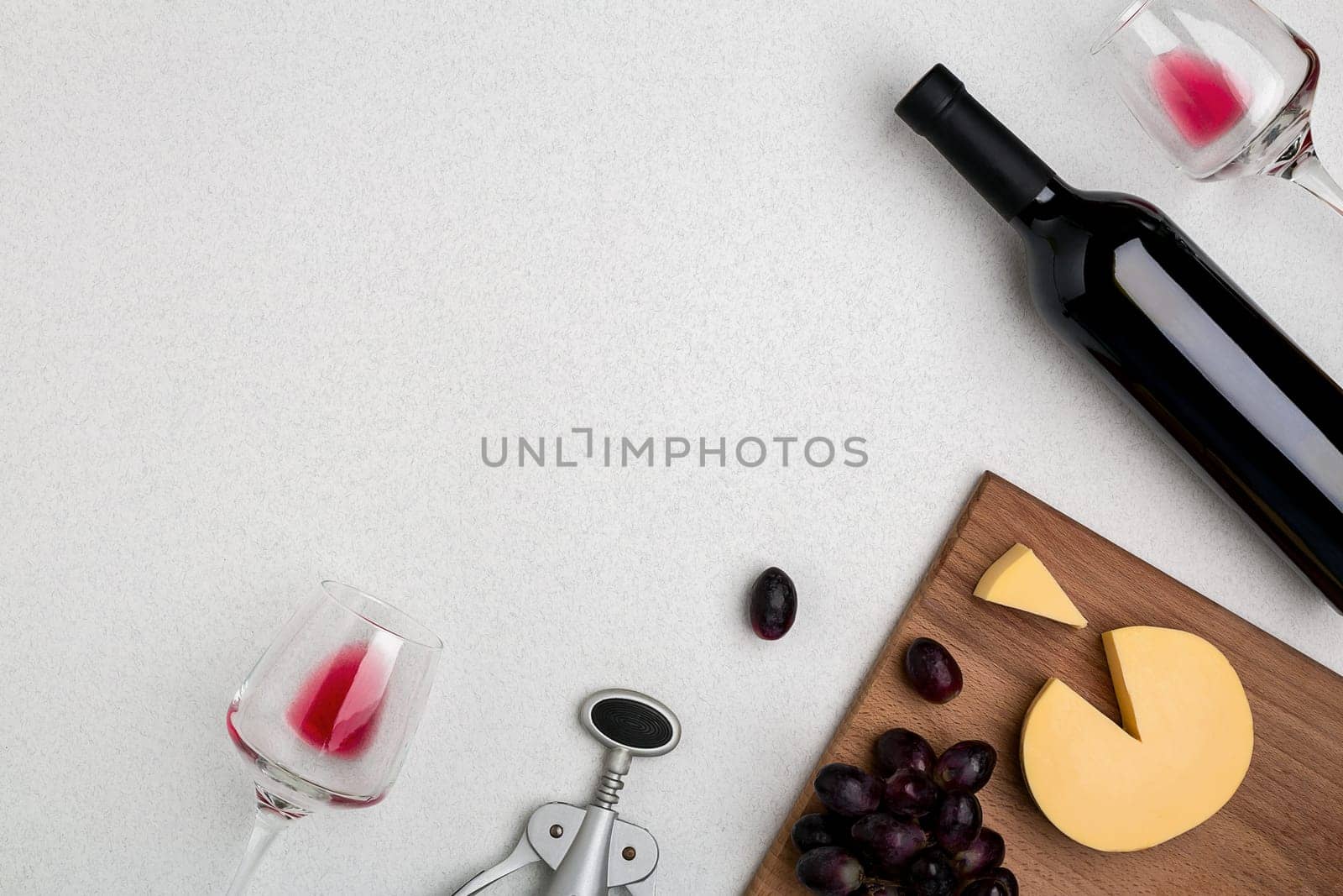 Wine, glasses and corkscrew over white background. Top view with copy space