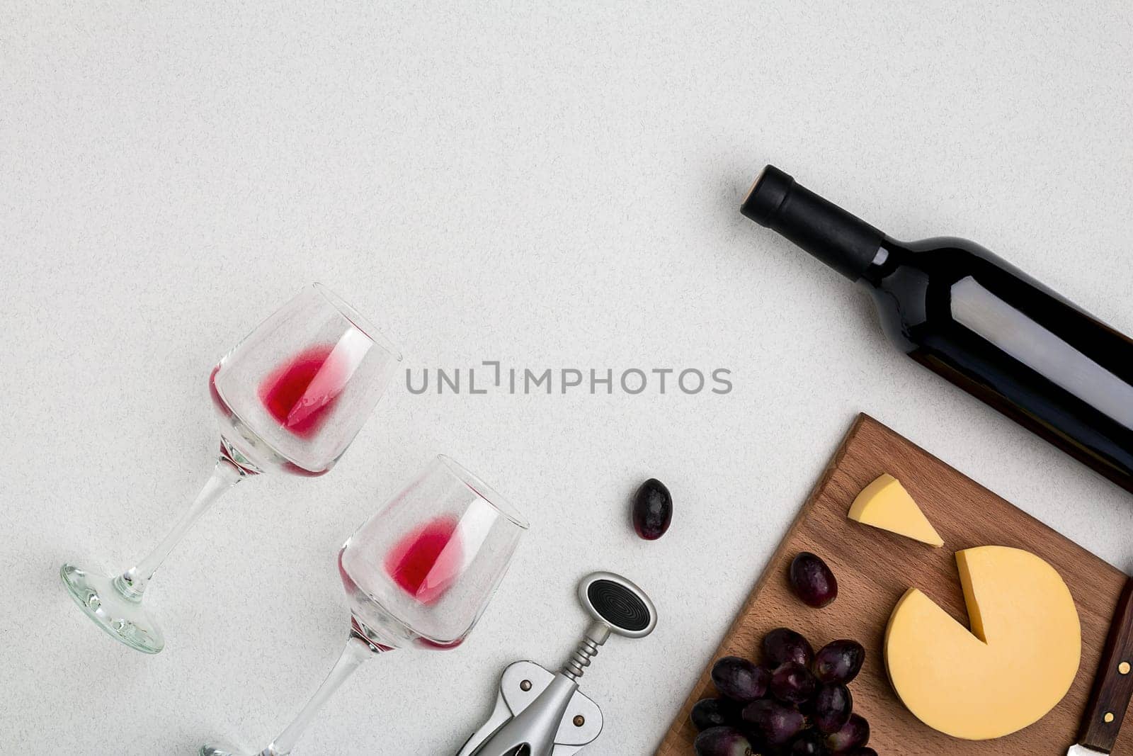 Wine, glasses and corkscrew over white background. Top view with copy space