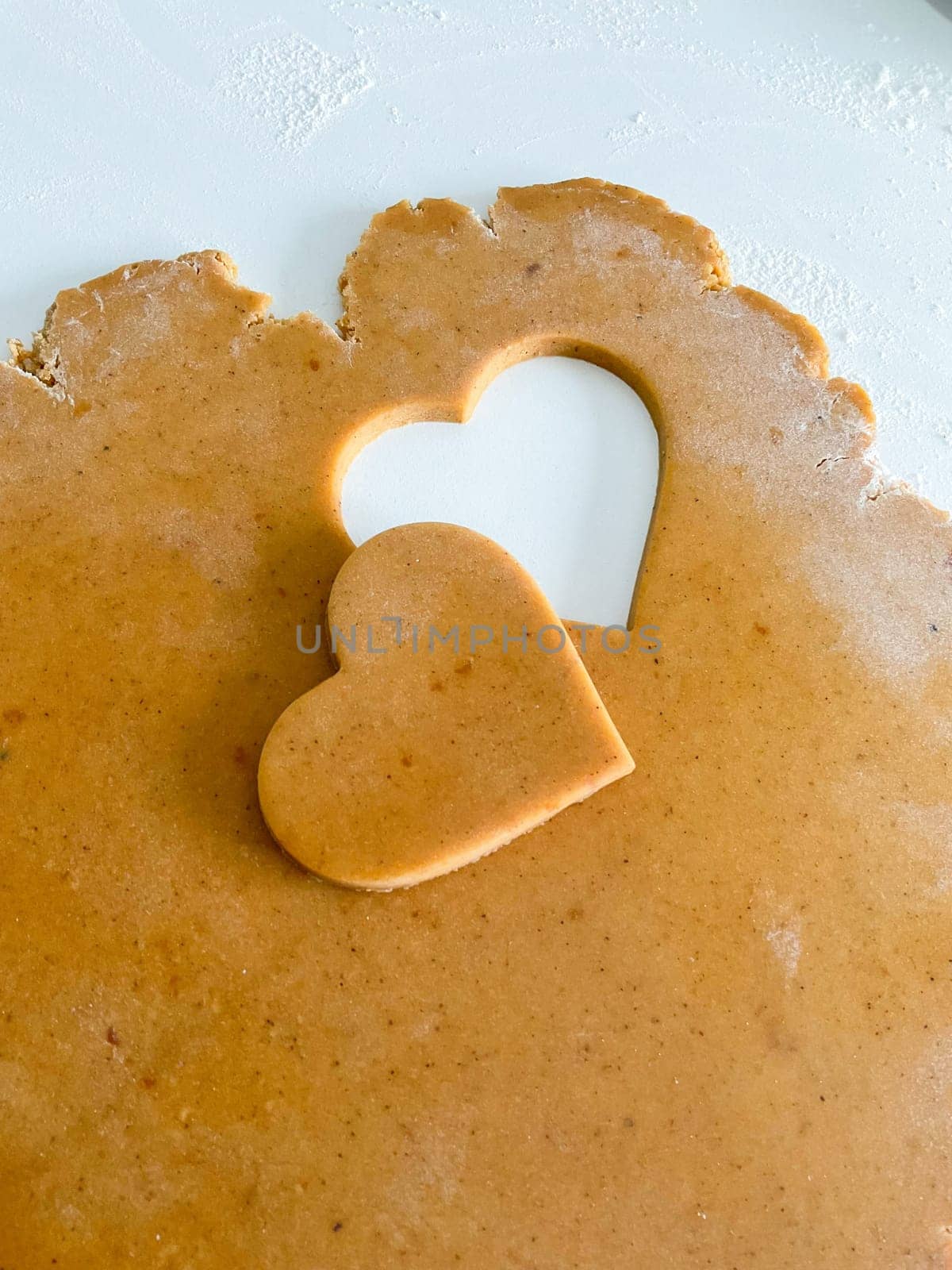 The process of making heart cookies. Top view of raw dough, rolling pin for baking