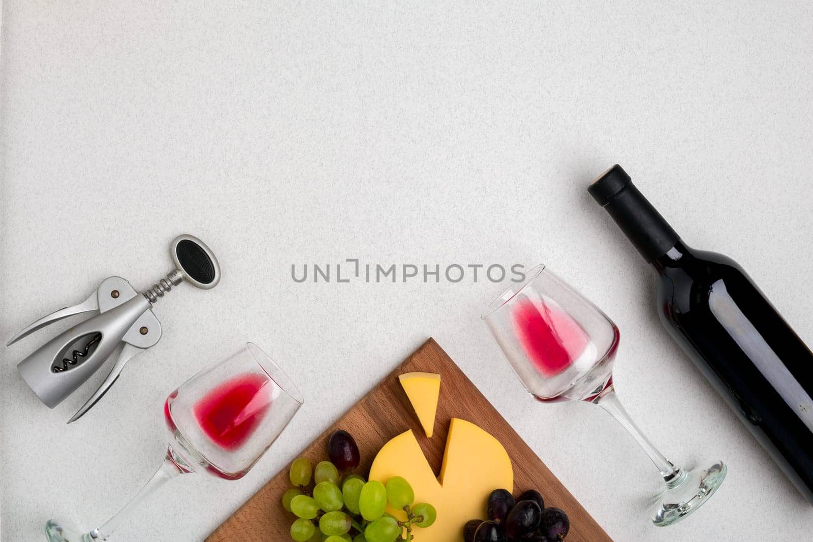 Wine, glasses and corkscrew over white background. Top view with copy space